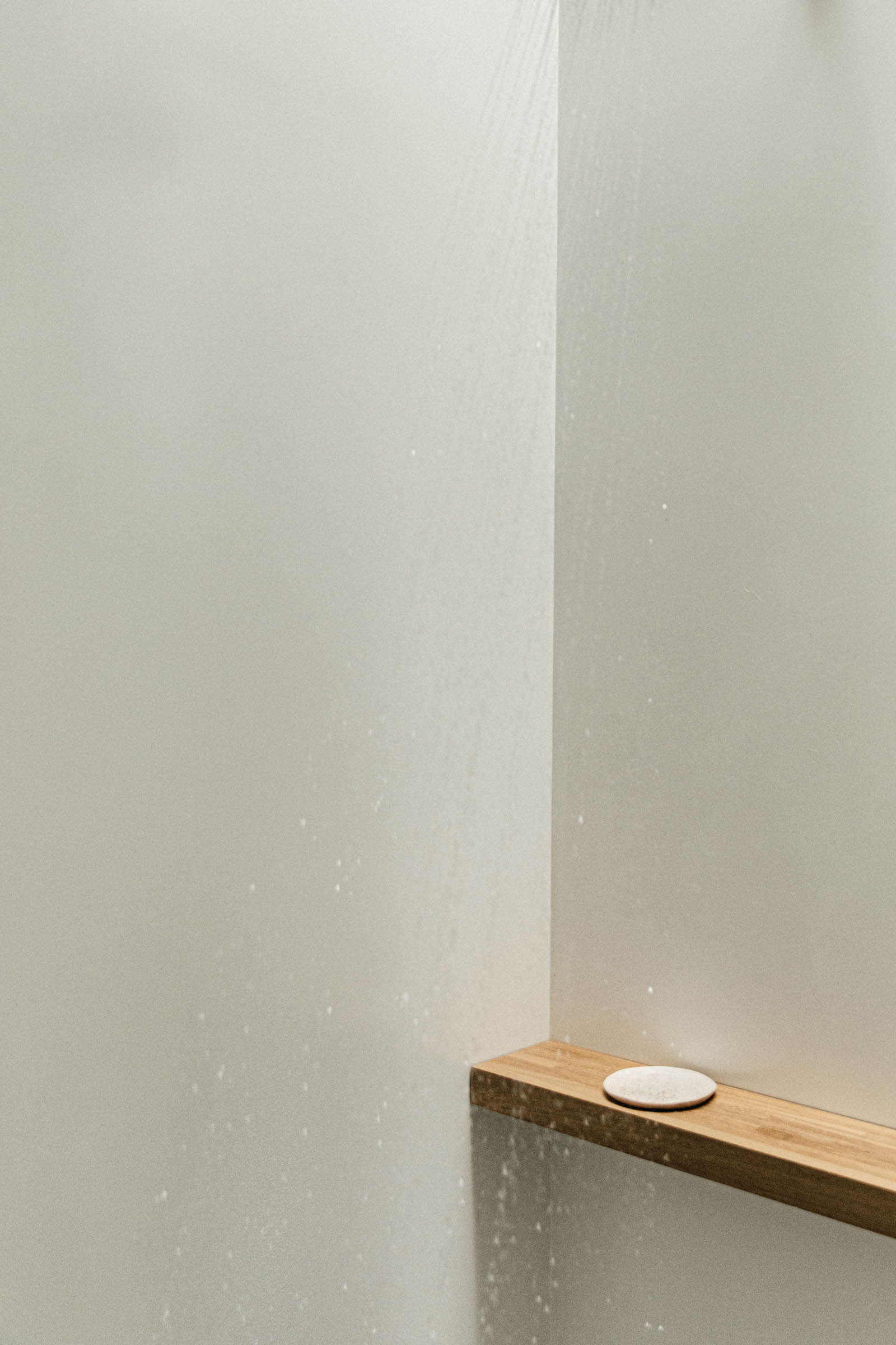Octavia Casa, Mexico — Minimalist corner with white drywall, wooden shelf, and ceramic vessel casting soft shadows in natural light