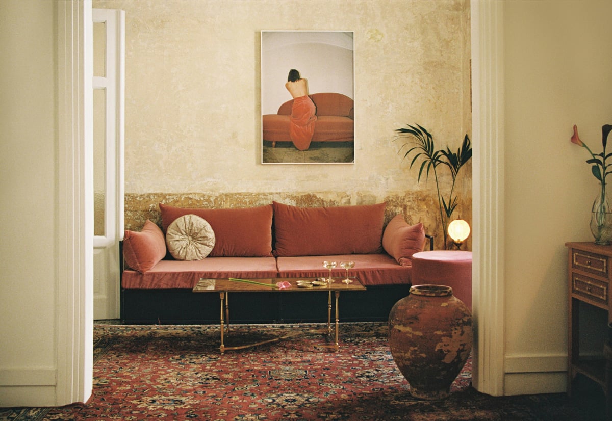 Shila, Europe — Terracotta seating alcove with brass coffee table, patterned rug, and ochre-toned walls in luxury hotel lounge.