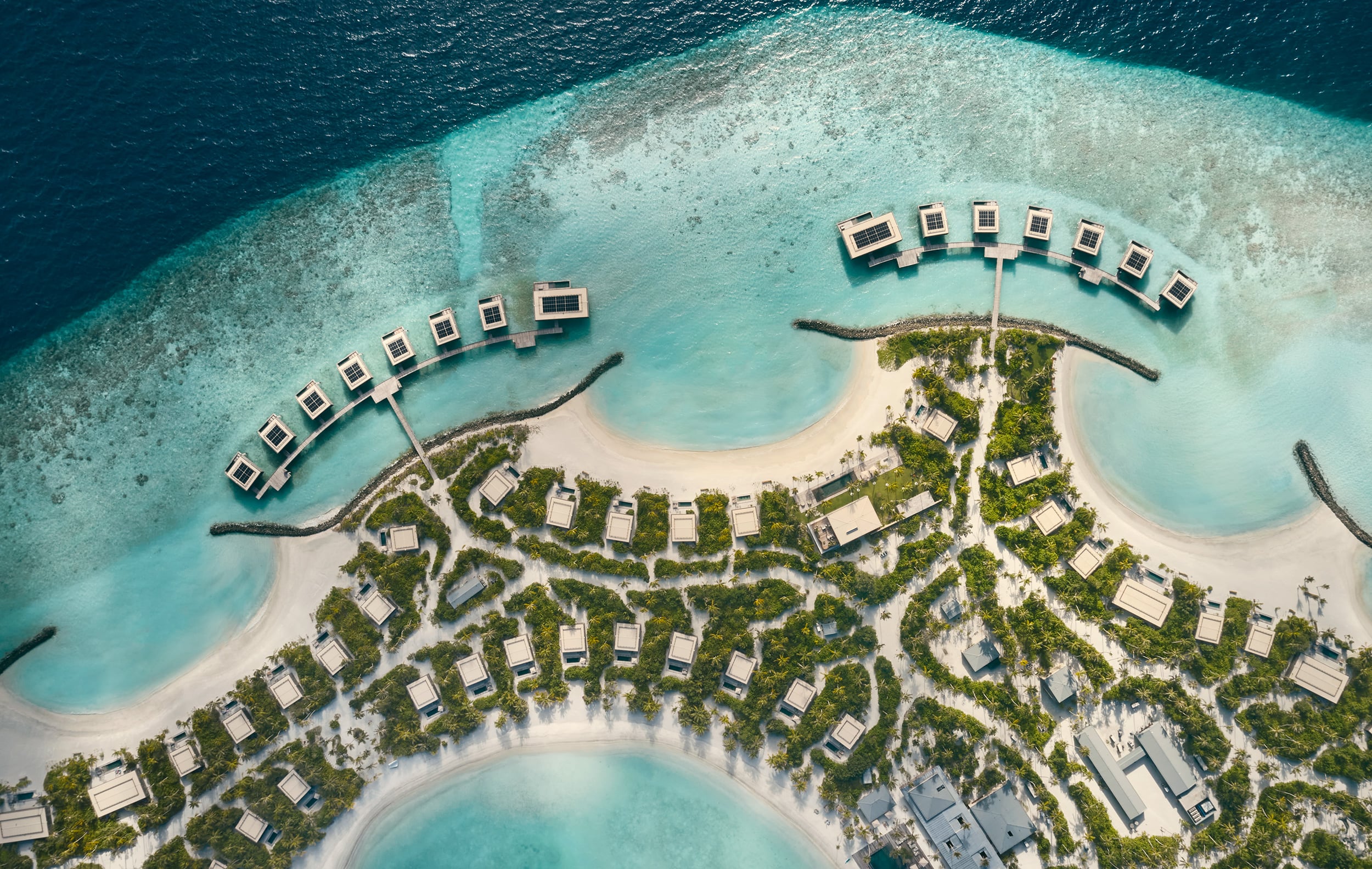 Patina Maldives, Asia — Aerial view of overwater bungalows and beachfront villas with turquoise lagoons, white sand, and lush tropical landscaping.