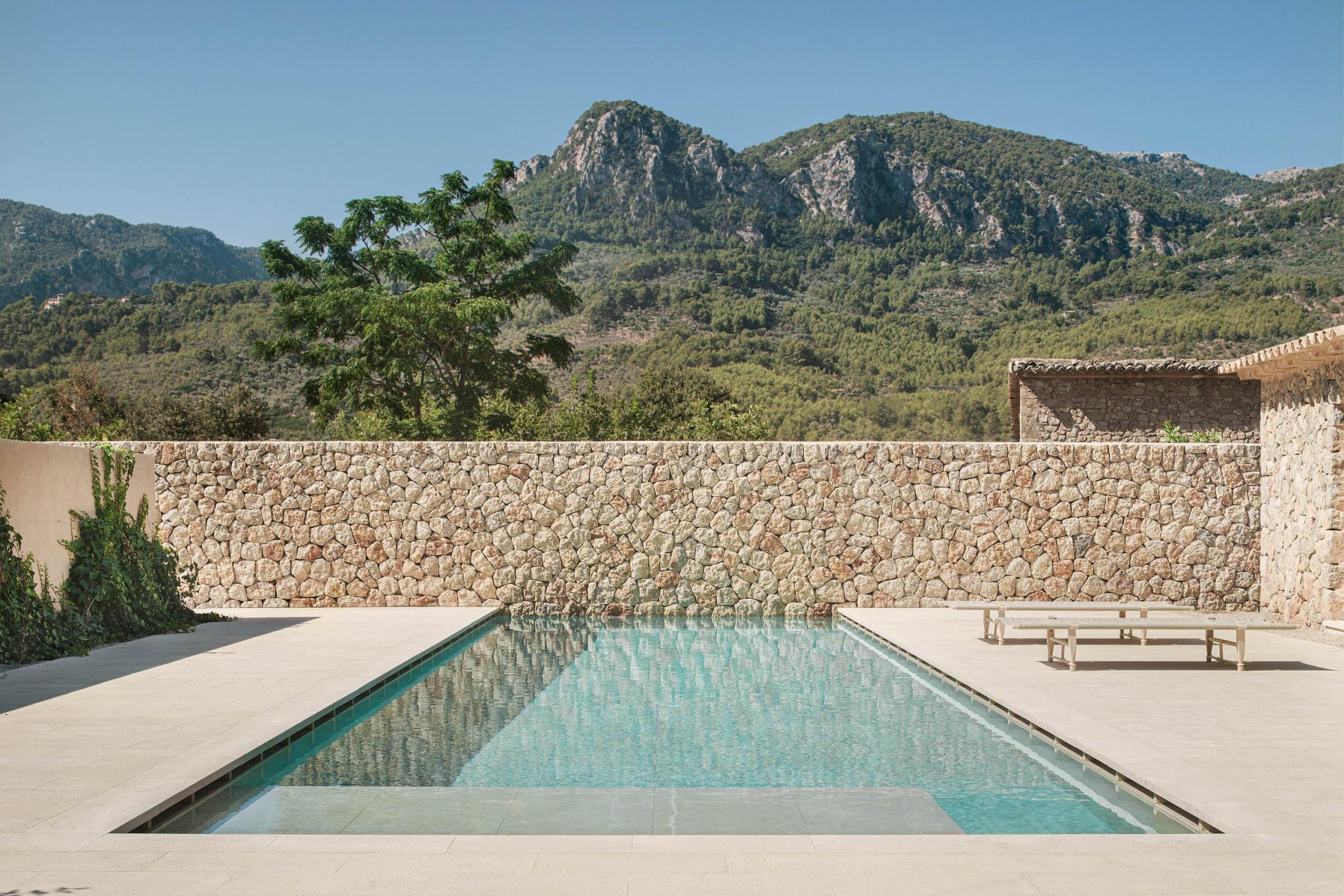 Minimalist limestone pool terrace overlooking forested mountains, Can Gaspar, Balearic Islands.