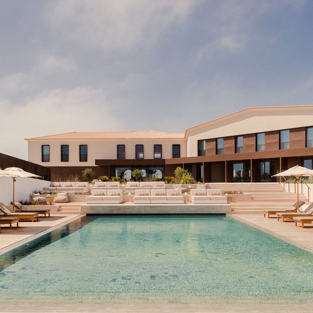 Aethos Ericeira, Portugal — Modernist terracotta and cream villa with zero-edge pool, teak loungers, and minimalist courtyard under soft daylight.