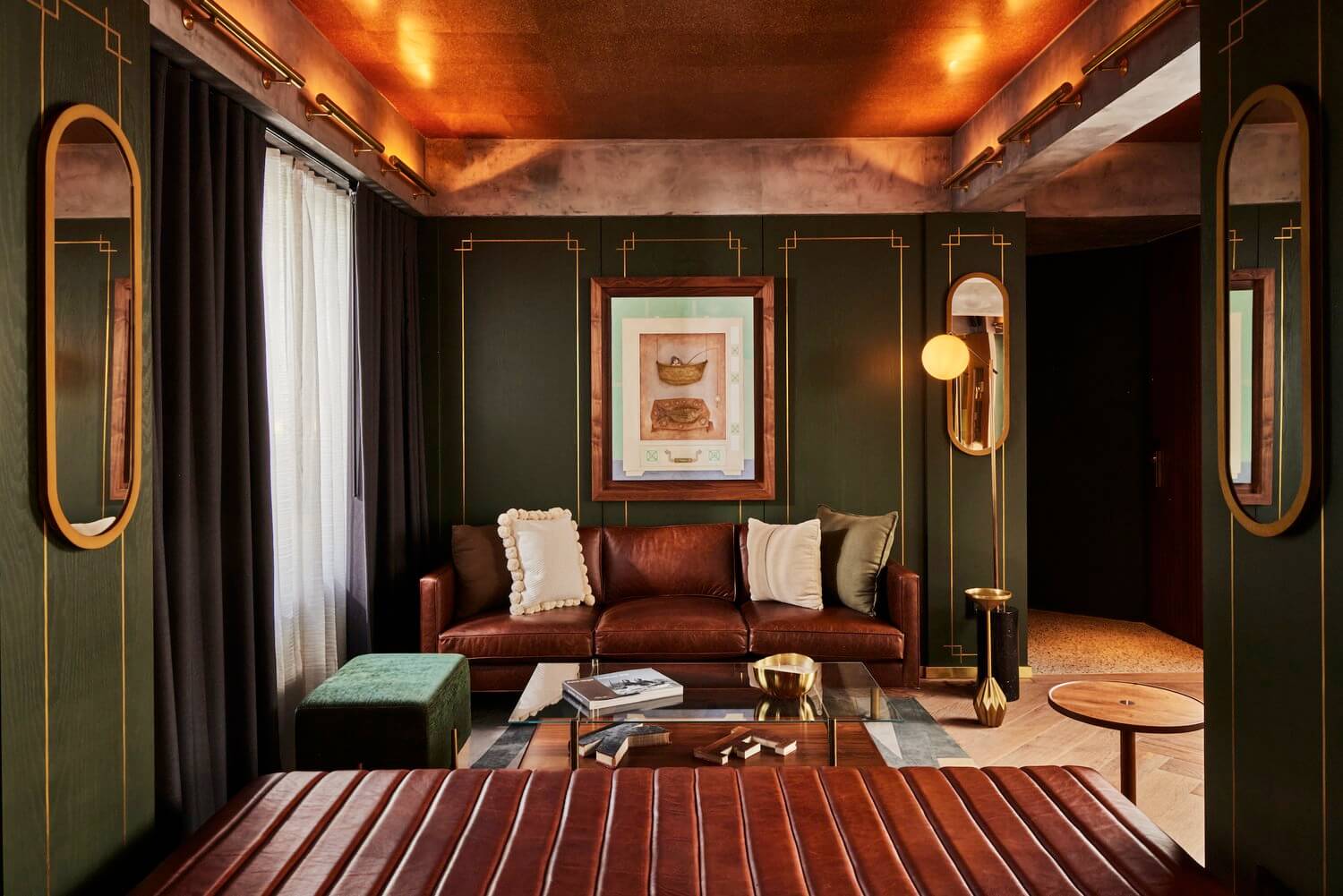 Campos Polanco, Mexico — Cognac leather sofa with art deco mirrors, copper ceiling, forest green paneling, and brass accents in luxury lounge space.