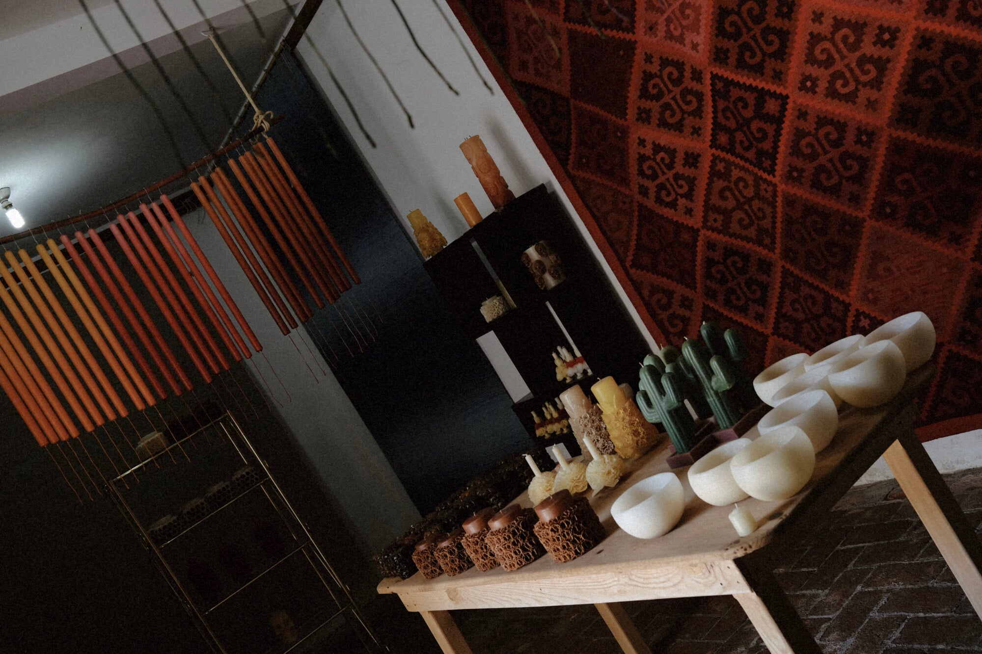 Casa Viviana, Mexico — Artisanal bread and pastries displayed on wooden shelf with white ceramic vessels, woven textiles, and warm ambient lighting in rustic hospitality setting.
