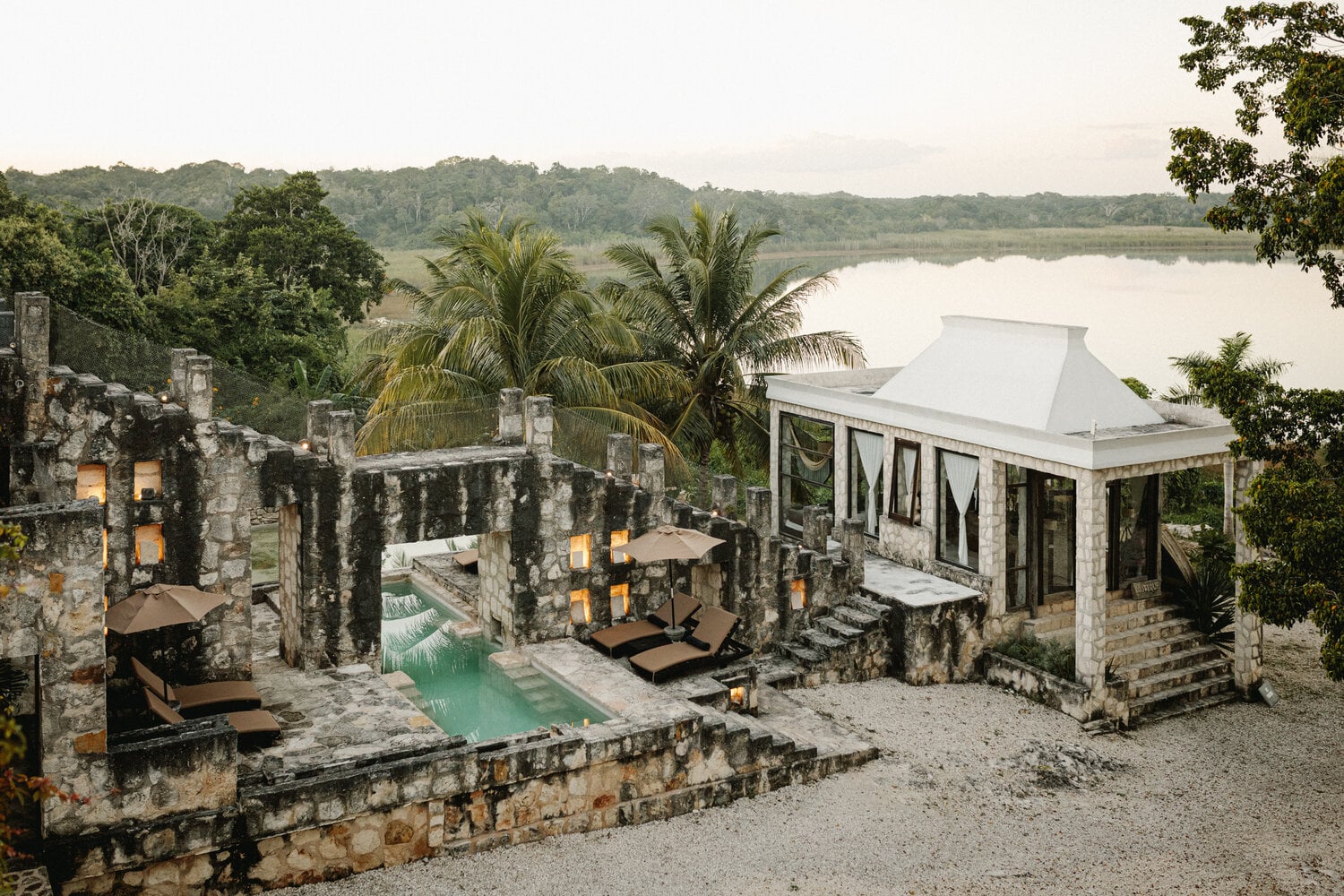 Coqui Coqui, Mexico — Stone spa pavilion with turquoise pool, palm trees, and river views overlooking tropical jungle landscape.