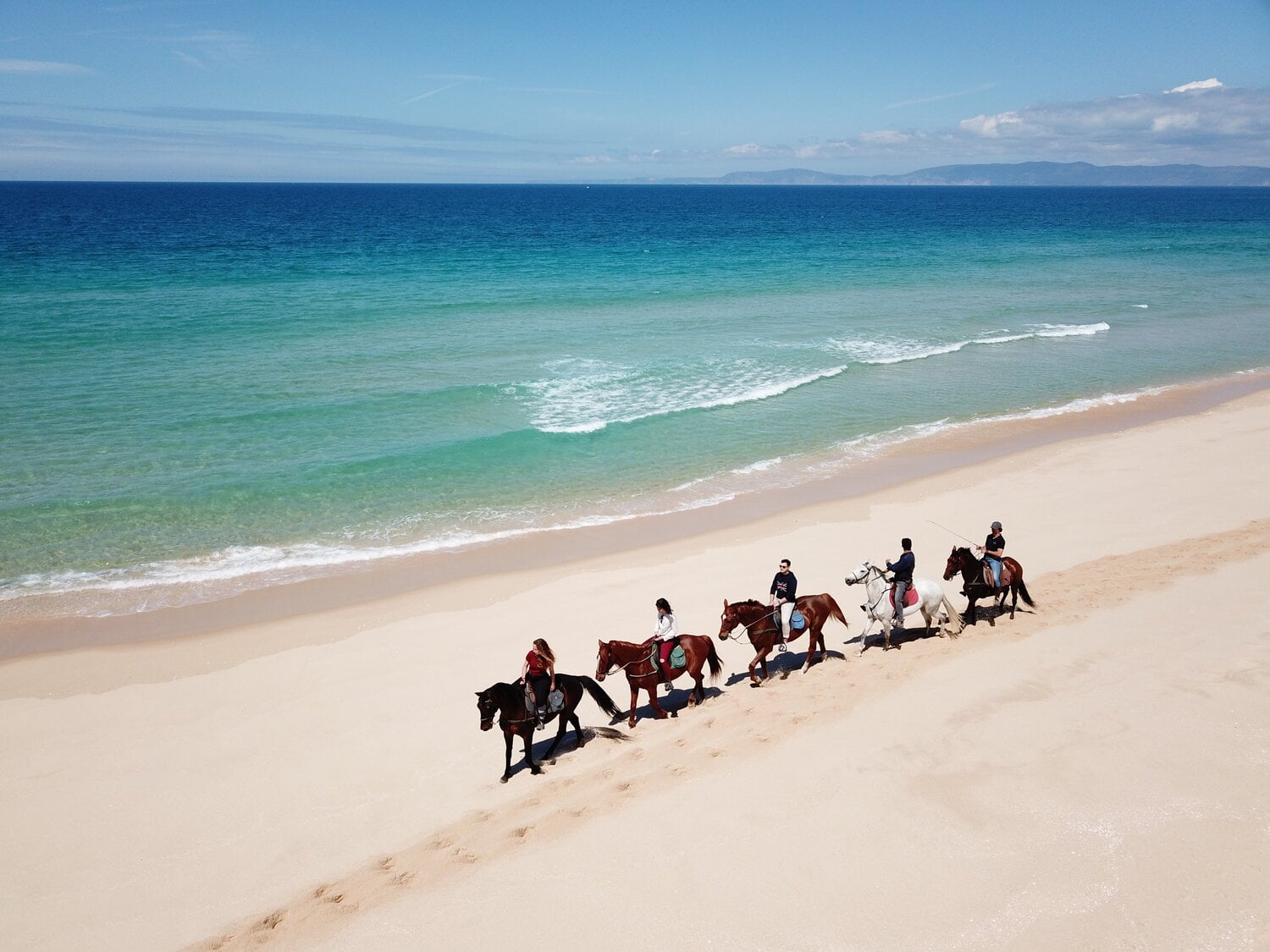 Horse Riding with Cavalos na Areia — Horse riding on pristine beach with turquoise water and white sand, coastal luxury experience in Europe.