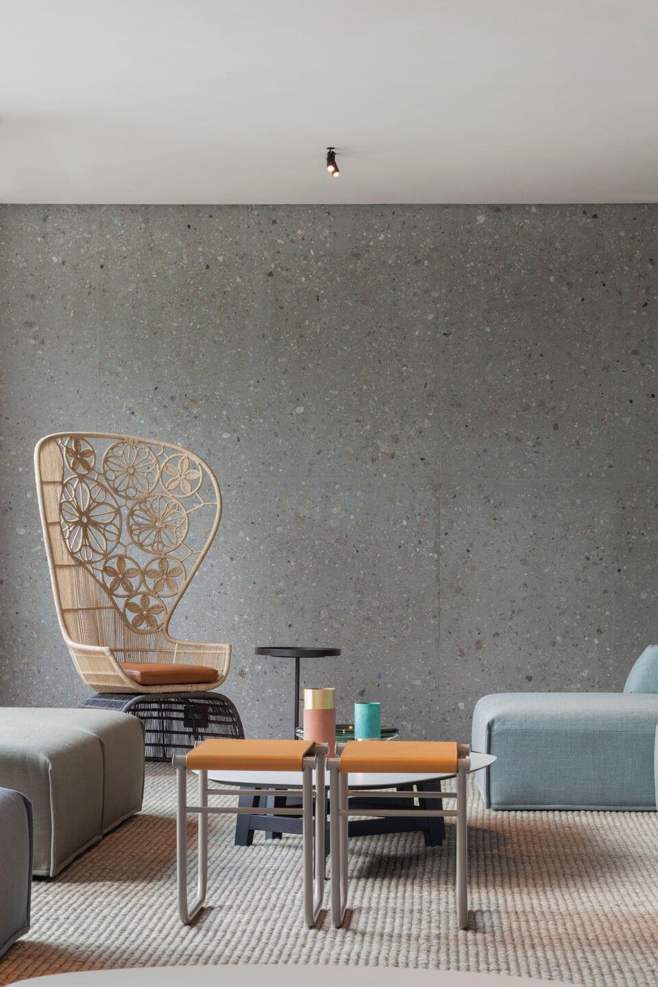 il Sereno Lago di Como, Italy — Minimalist lounge with geometric wooden chair, neutral seating, and concrete walls bathed in natural light.