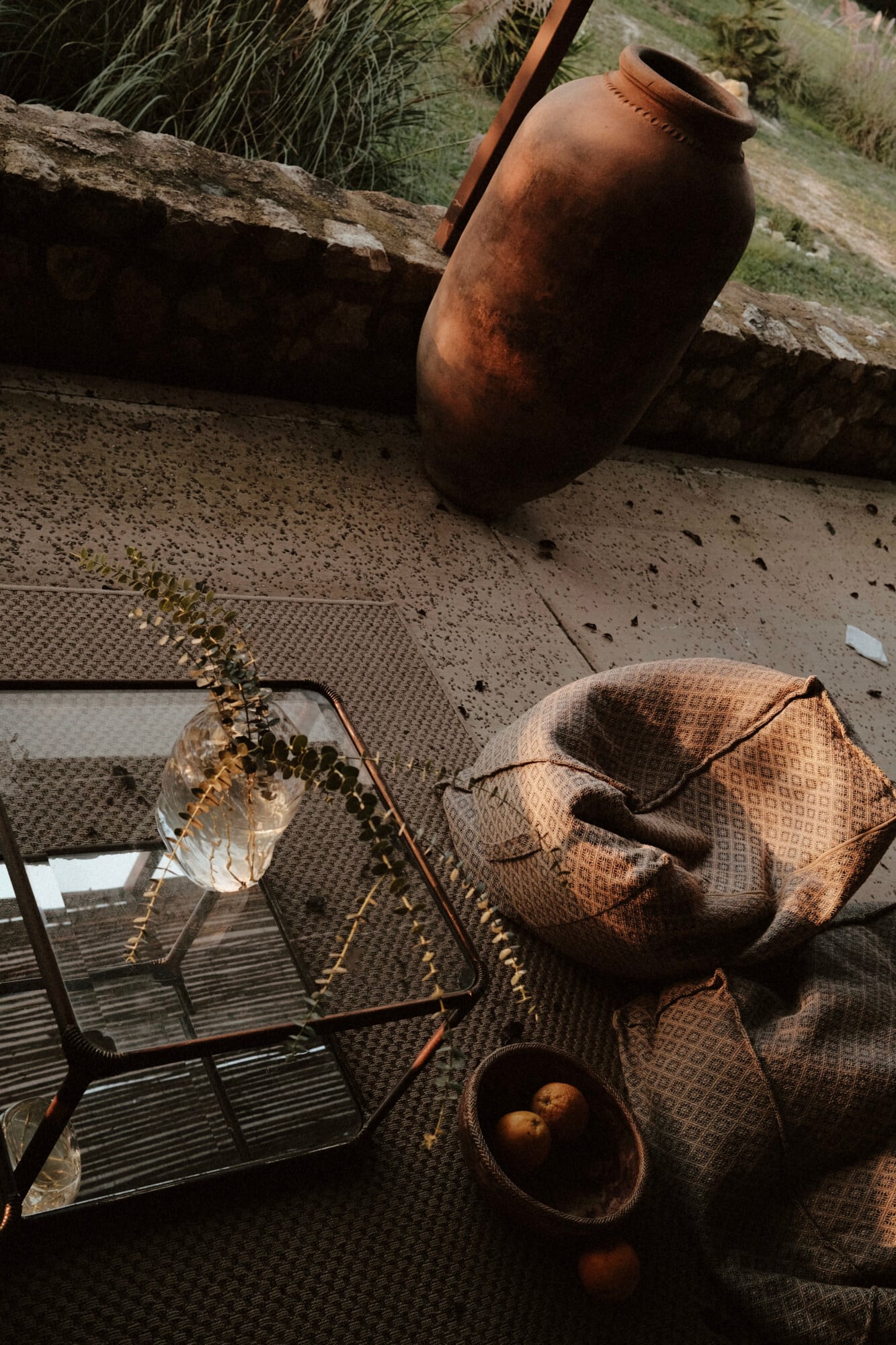 Vista Verde, Balearic Islands — Terracotta vessel and woven textiles arranged on concrete terrace with dried botanicals and natural light, Mediterranean villa styling.