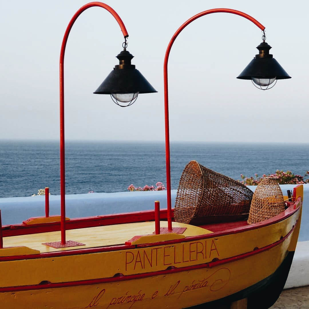 Osteria Il Principe e Il Pirata, Campania, Italy — Traditional fishing boat with red arched lamps overlooking Mediterranean Sea at coastal restaurant.