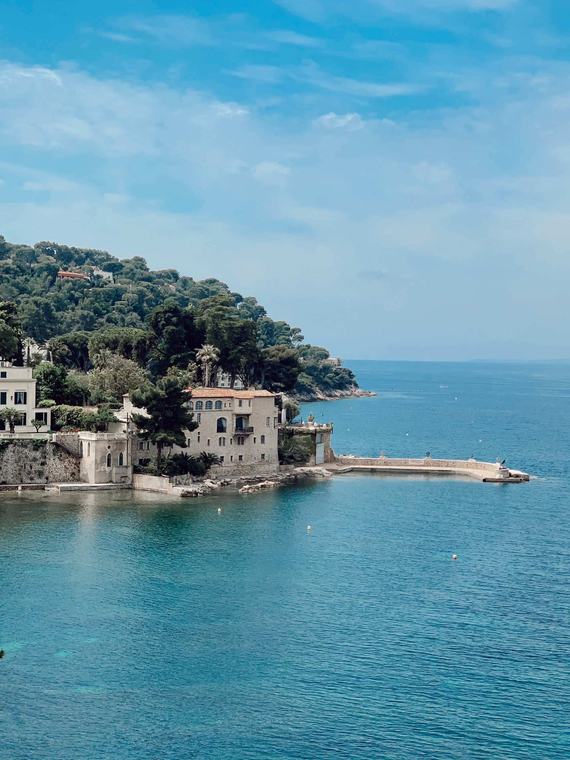 Secret beaches of the French Riviera — Coastal villa with stone architecture overlooking turquoise Mediterranean waters, French Riviera — luxury seaside property with terracotta roofing nestled among pine trees.