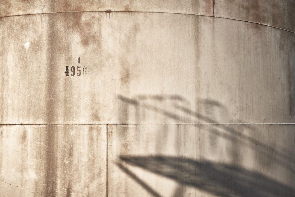 Dexamenes Seaside Hotel, Europe — Weathered concrete wall with shadow of staircase, minimalist industrial aesthetic, natural light and texture detail.