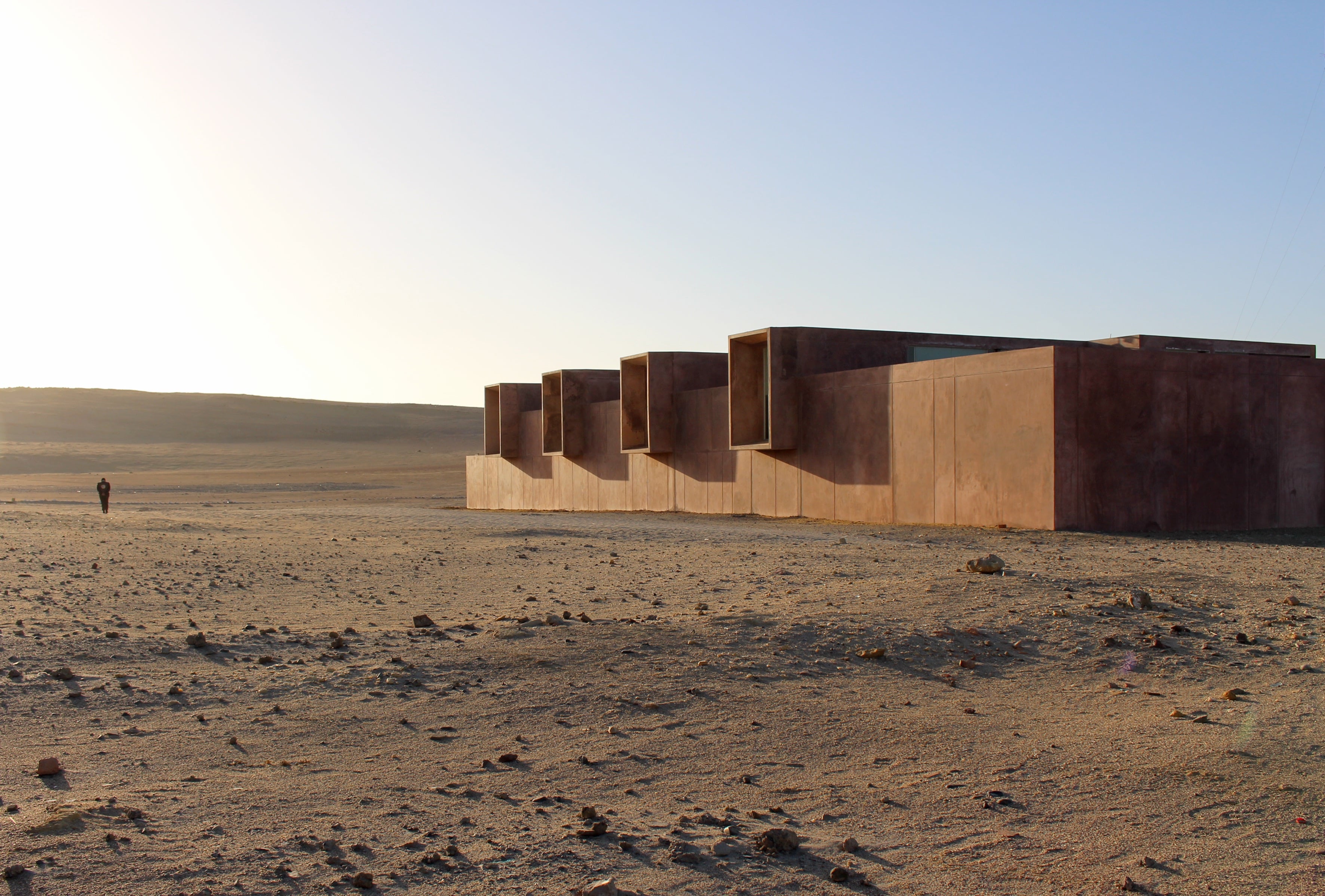 Barclay &amp; Crousse’s Museum of Ancient Culture | Peru — Barclay & Crousse's Museum of Ancient Culture, Peru — Weathered copper and timber pavilions with angular cutouts cast deep shadows across desert landscape.
