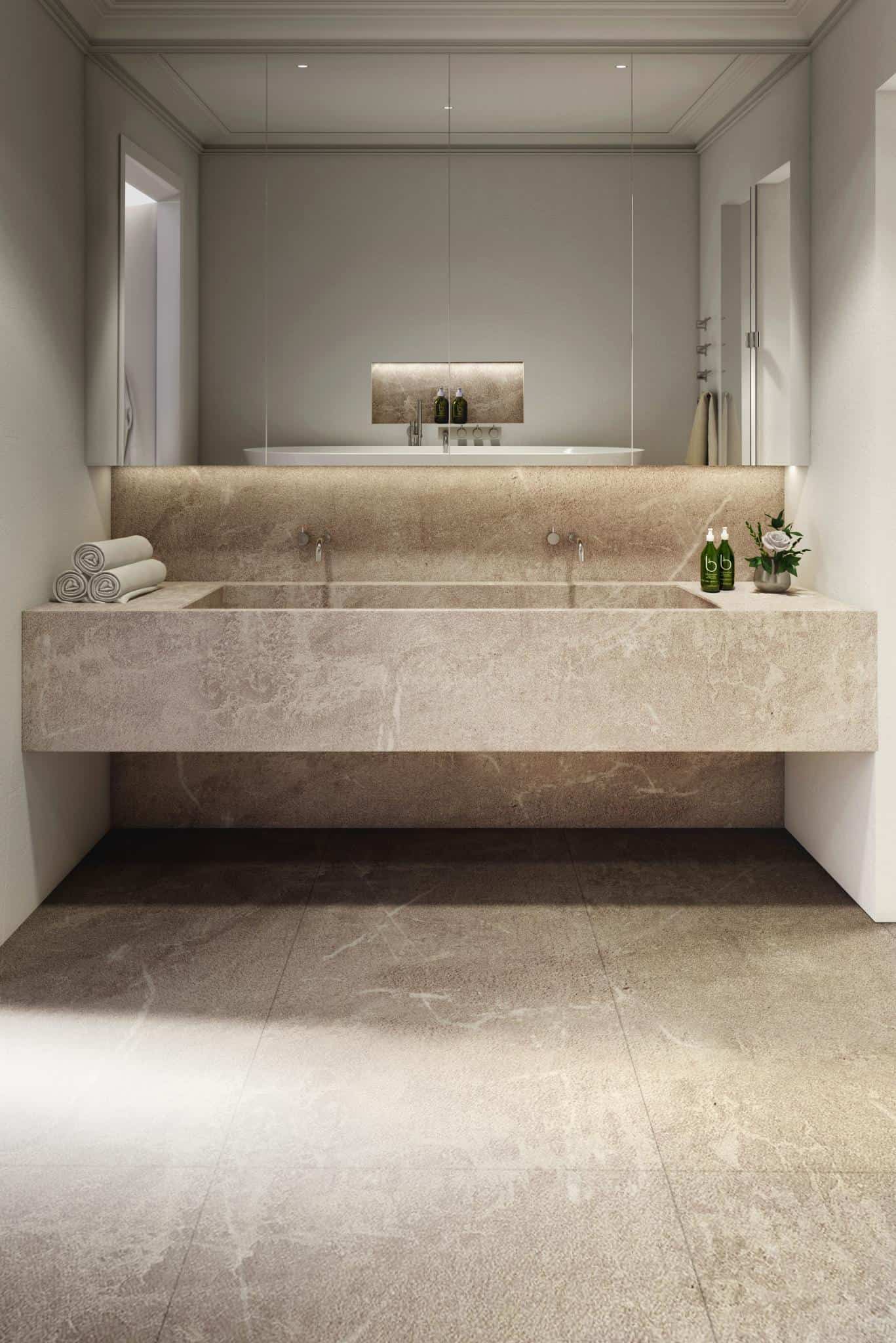 Renaissance Penthouse, Balearic Islands — Minimalist bathroom with limestone double vanity, backlit mirror, natural stone walls and floor, warm ambient lighting.
