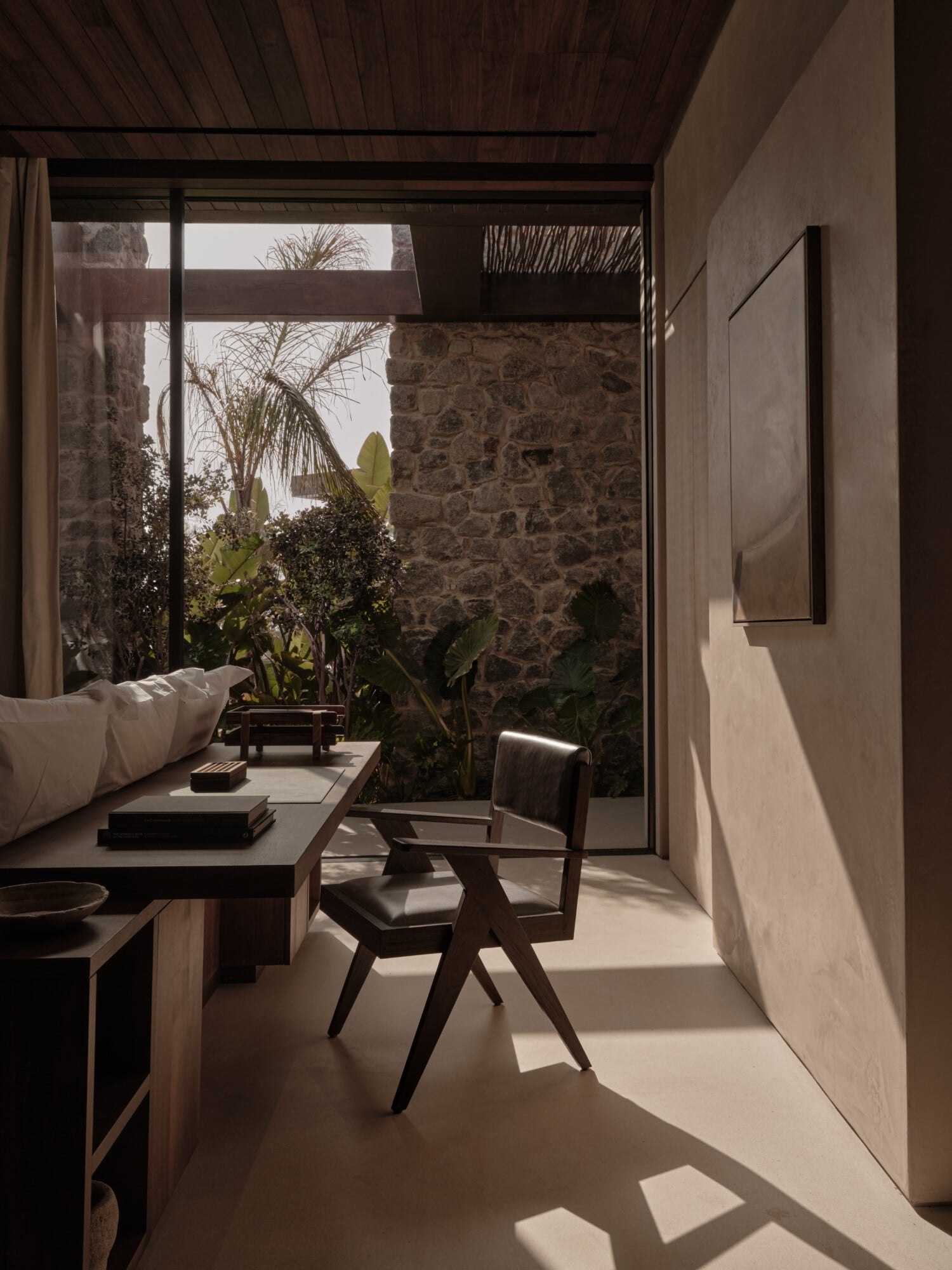 Scorpios Bodrum, Mediterranean — Minimalist bedroom with stone courtyard view, modernist furniture, natural light, desert plants, earthy neutral palette.