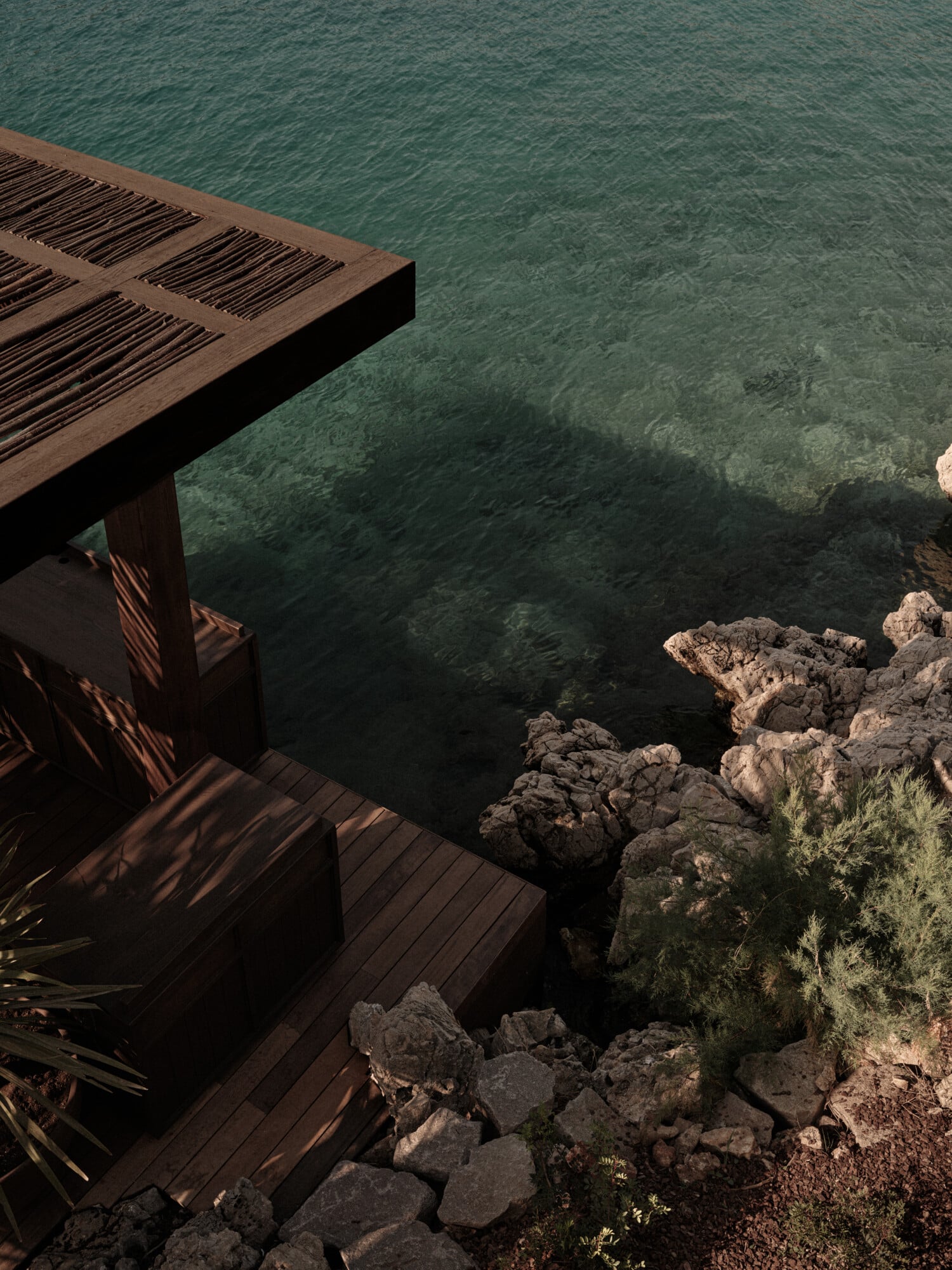 Scorpios Bodrum, Mediterranean — Wooden terrace with slatted louvres overlooking turquoise water, rocky coastline, and natural stone steps in golden afternoon light.