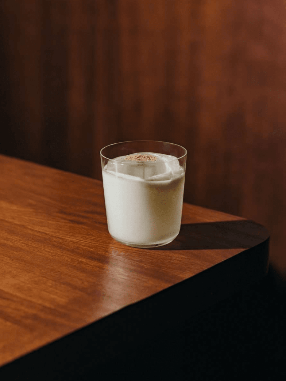 Casa Bonay, Europe — Creamy cocktail with spice garnish on wooden table against warm brown backdrop, luxury hospitality styling.