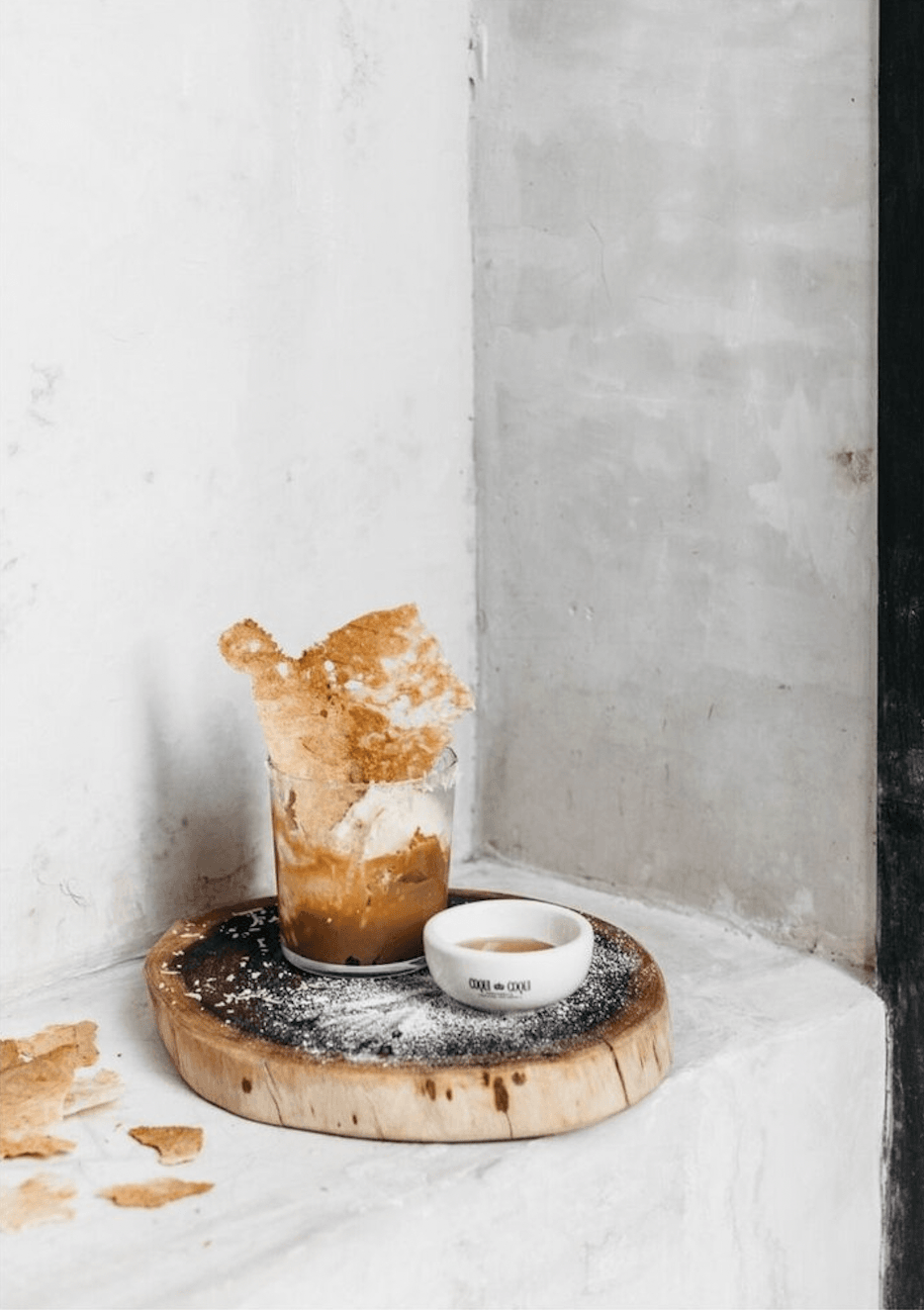 Coqui Coqui Papholchac, Mexico — Artisanal pastry with caramelized sugar on wooden board, minimalist styling with concrete walls and natural light.