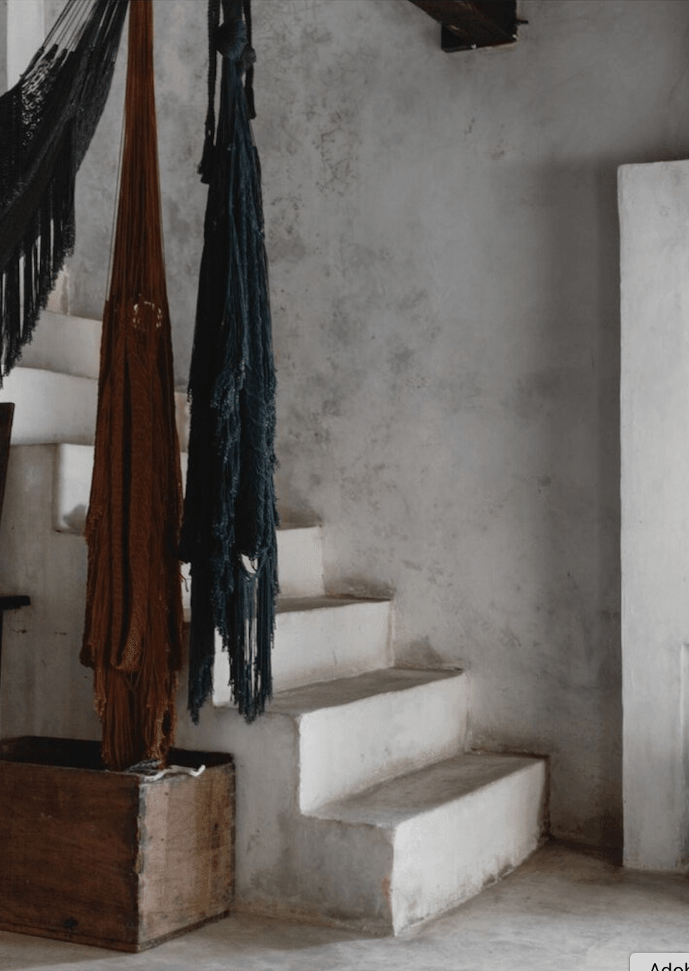Coqui Coqui Papholchac, Mexico — Whitewashed staircase with woven textile hangers and rustic plaster walls, minimalist colonial architecture.