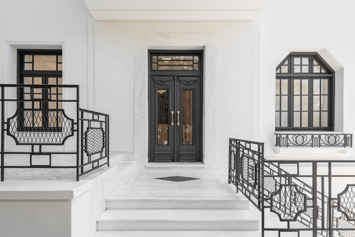 Gagosian Gallery, Europe — Minimalist white corridor with black-framed doors, windows, and geometric railings, gallery lighting and refined architectural details.