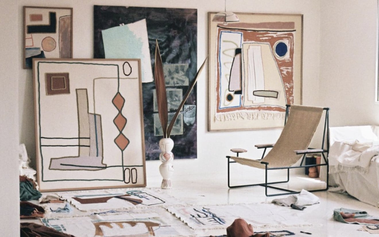 LRNCE, Africa — Creative studio interior with framed abstract line drawings, tan canvas chair, natural light, and artistic workspace scattered with sketches and design materials.