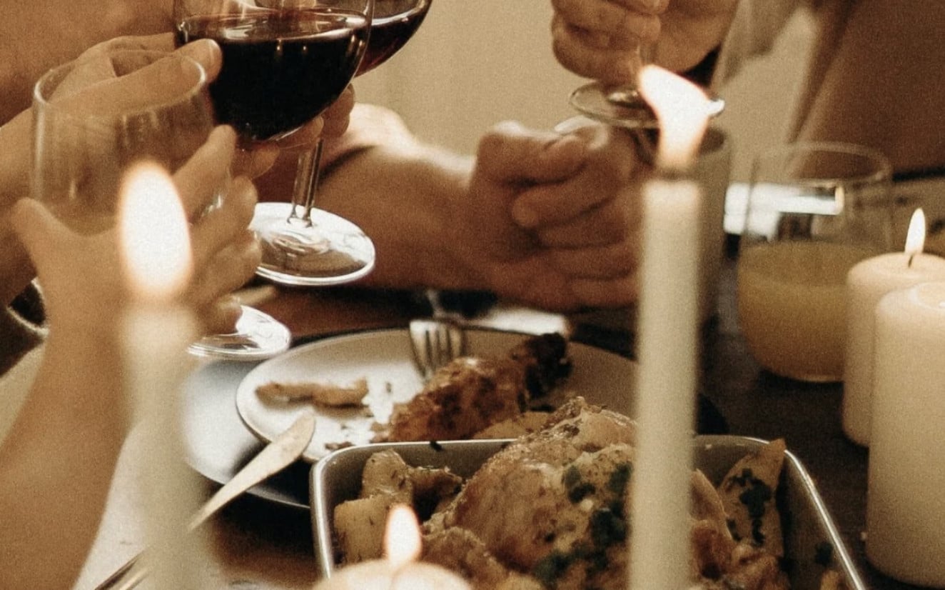 FLX Wienery & Table, North America — Candlelit dinner table with wine glasses, plated food, and warm ambient lighting during intimate evening service.