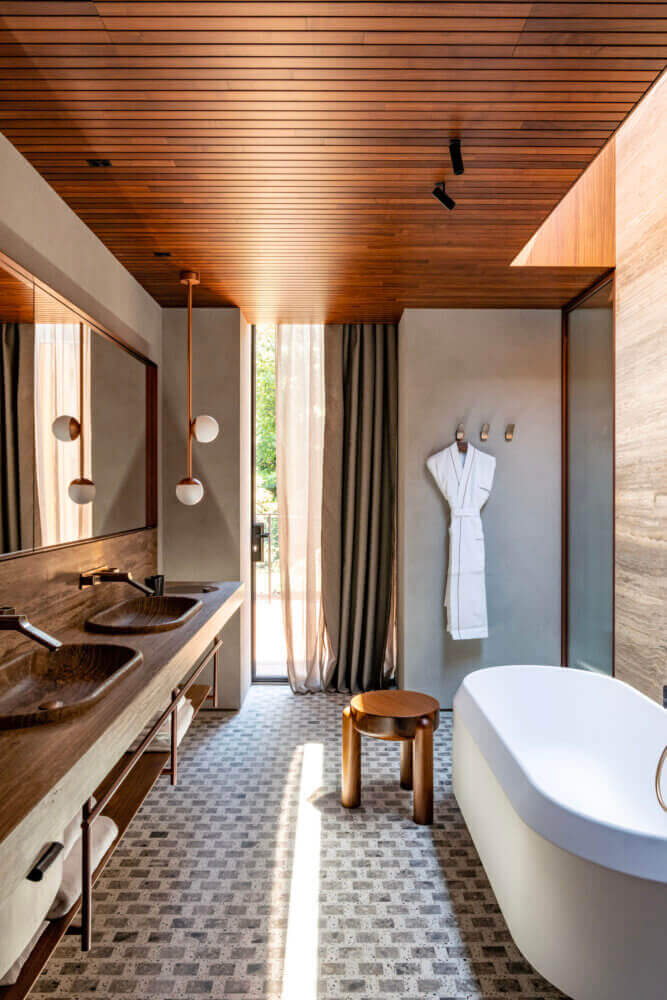 il Sereno Lago di Como, Europe — Modern spa bathroom with wood-paneled ceiling, dual vanities, freestanding tub, natural light, and minimalist design details.