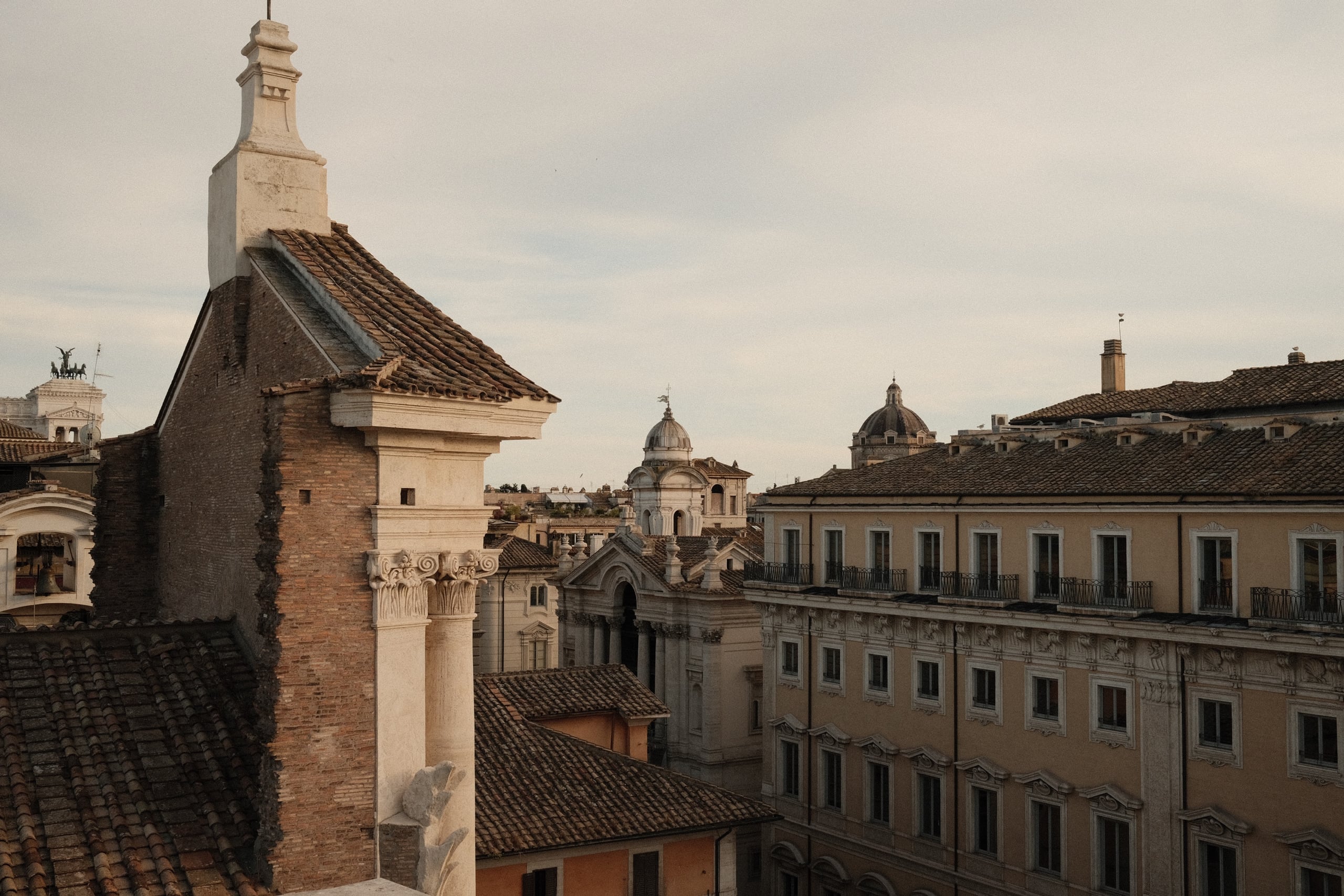 Six Senses Roma — Roman rooftops and domes seen from the hotel at dusk, photographed by KOBU