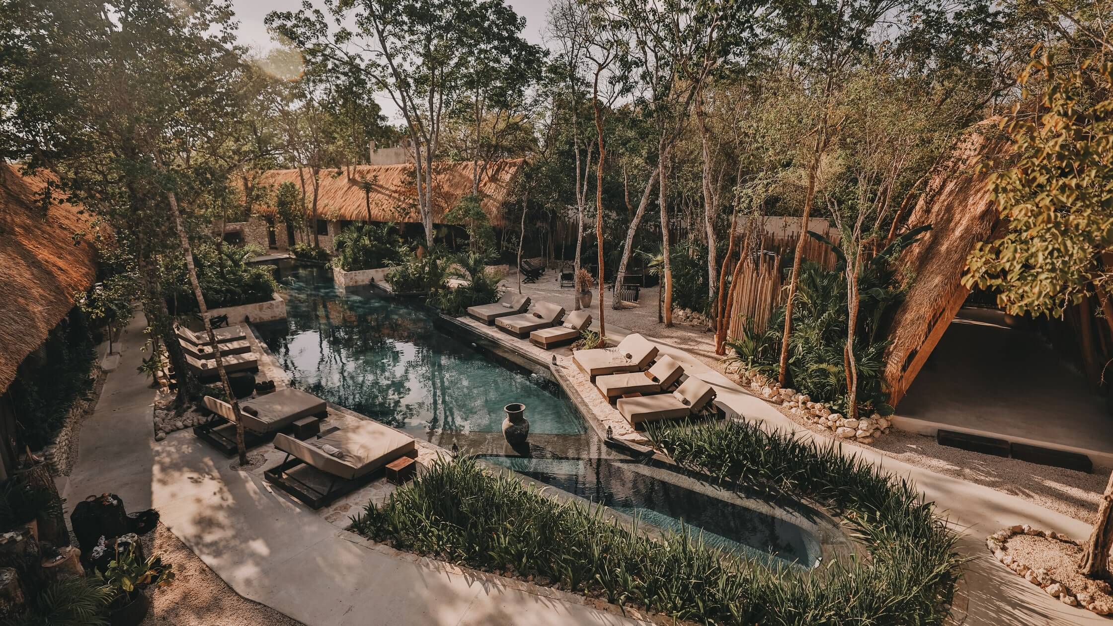Bardo, Mexico — Turquoise pool nestled between terracotta walls and tall eucalyptus trees, with loungers and minimalist architecture in warm sunlight.