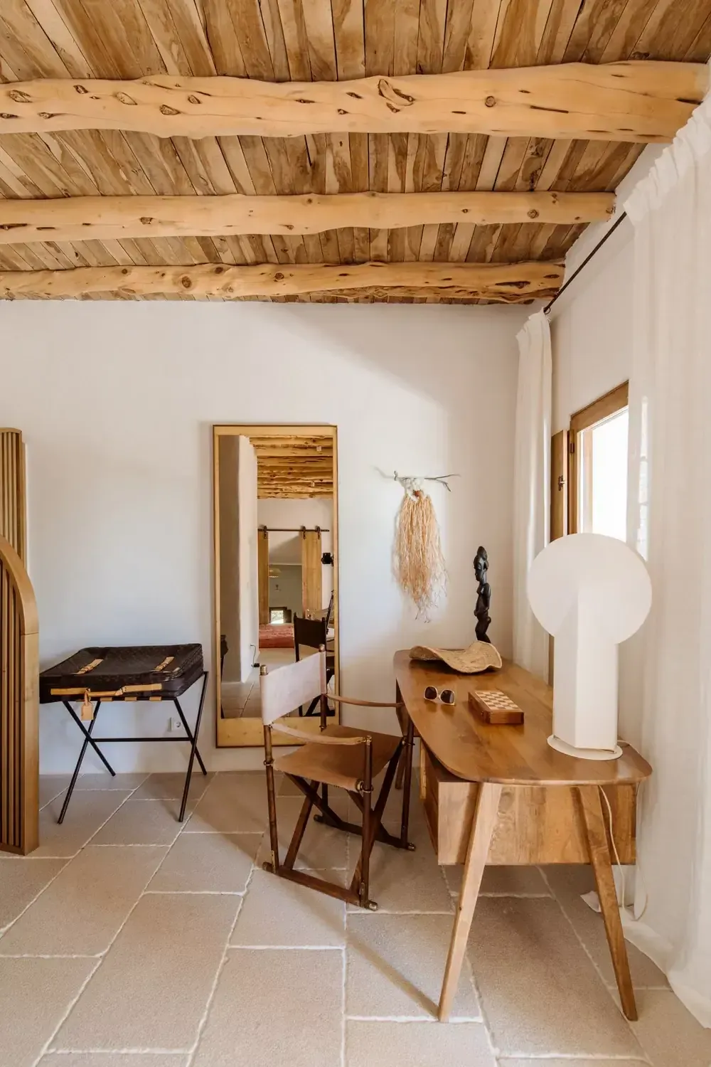 Finca La Inika, Balearic Islands, Spain — Minimalist bedroom with exposed wooden beams, natural light, wooden furniture, and neutral palette in luxury villa.