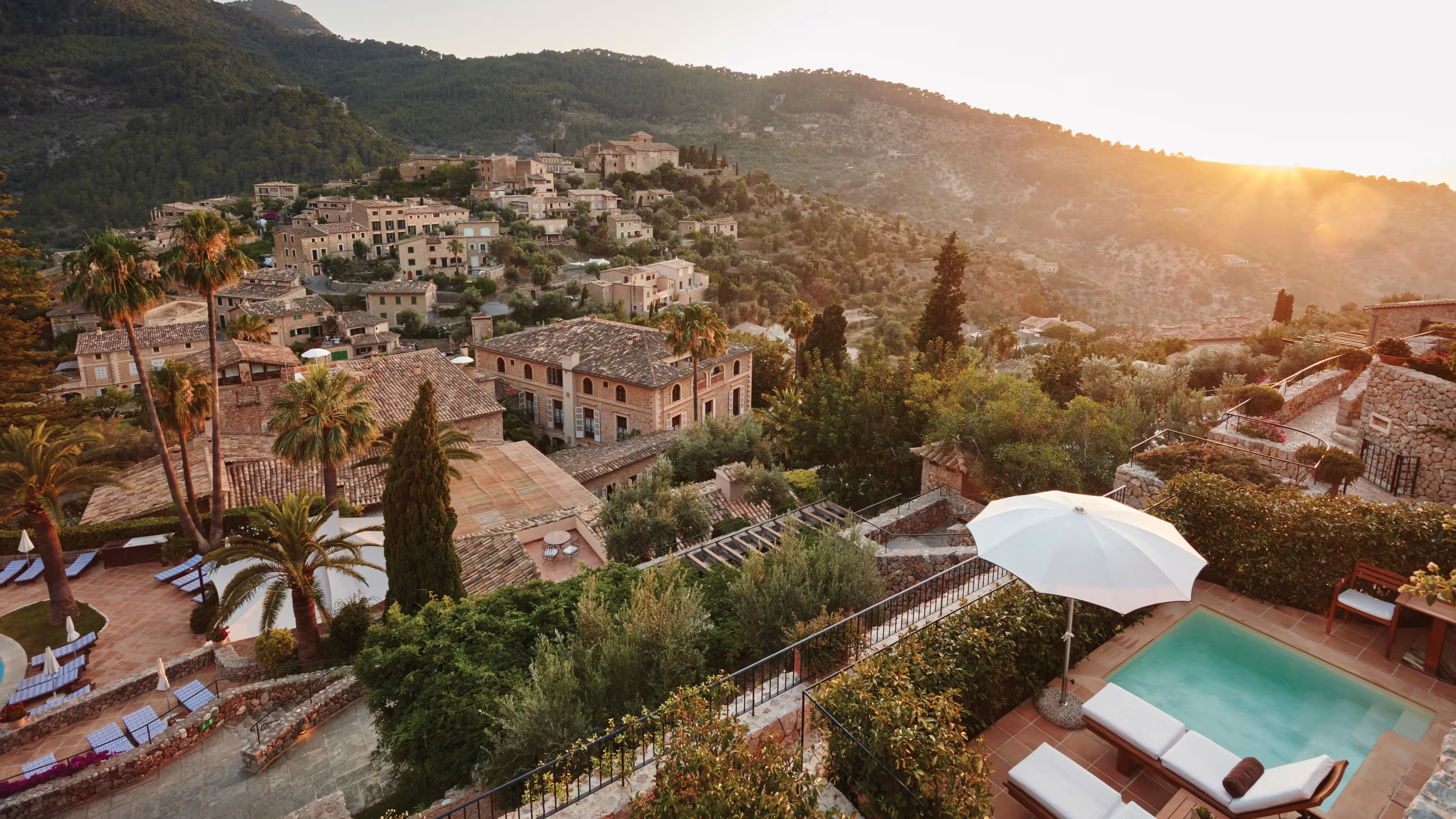 Belmond La Residencia, Balearic Islands, Spain — Hilltop Mediterranean villa with terracotta roofing, cypress trees, infinity pool, and golden-hour mountain vistas.