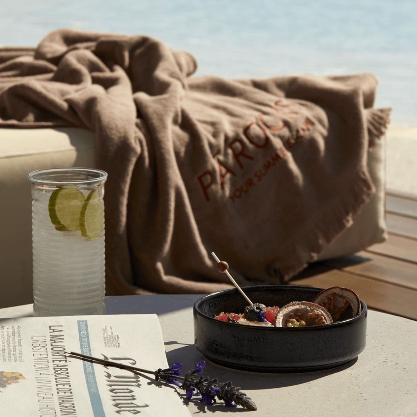 Pārocks, Europe — Coastal terrace with linen napkins, lime-infused water glass, black ceramic bowl of figs, and seaside views at dusk.