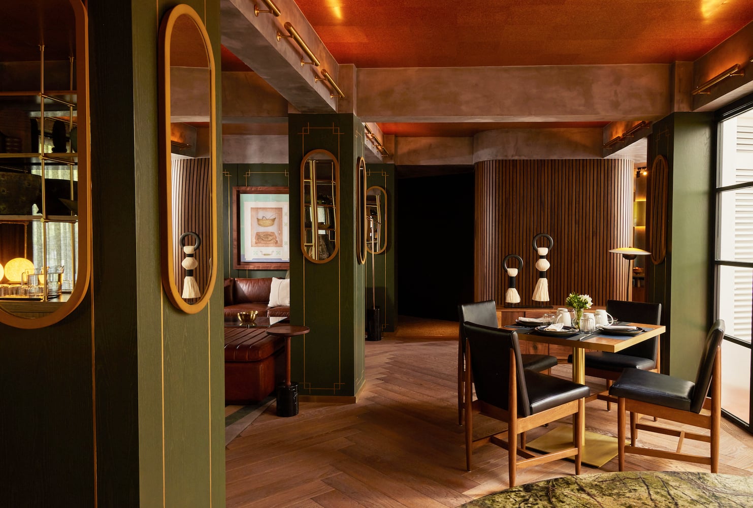 Campos Polanco, Mexico — Art deco suite with warm wood paneling, brass-trimmed mirrors, ochre ceiling, leather seating, and desk workspace with natural light from louvered windows.