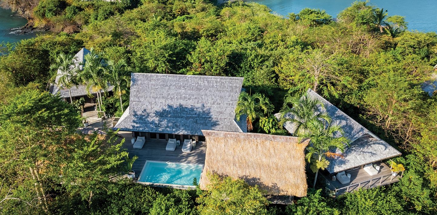 Islas Secas, Panama — Luxury villa with thatched-roof pavilions, infinity pool, and dense tropical forest overlooking turquoise ocean waters.