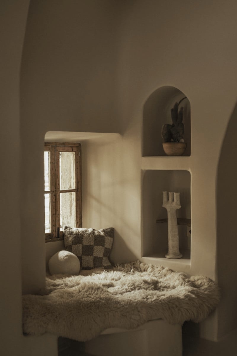 Hotel Corazón, Balearic Islands — Whitewashed alcove with arched niches, natural light, cream textiles, sculptural objects, Mediterranean minimalist interior design.