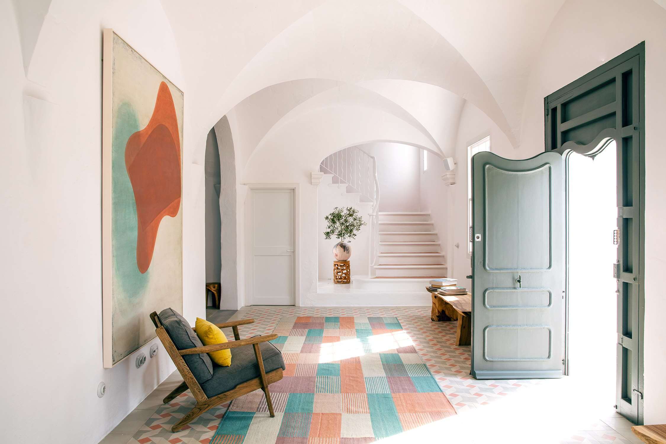 Es Bec d’Aguila — Es Bec d'Aguila, Balearic Islands, Spain — Vaulted corridor with arched ceilings, geometric tile floor, modernist artwork, mid-century furniture, and seafoam doors.