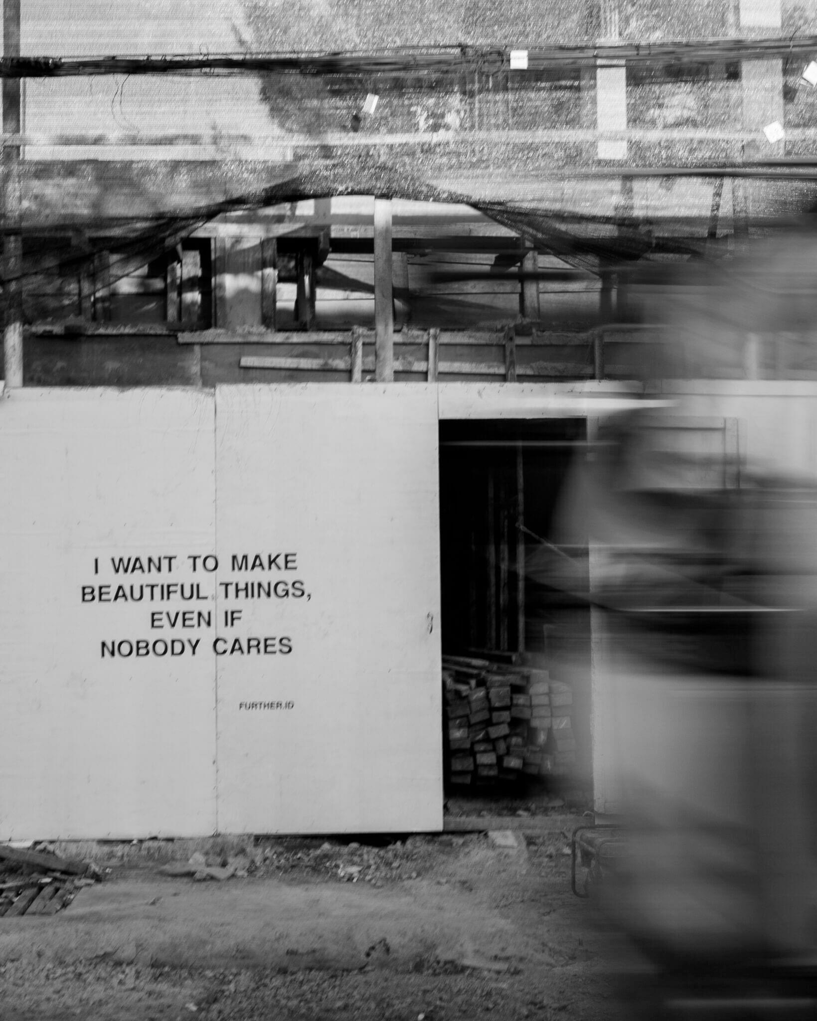 Further Hotel, Asia — Black and white photograph of industrial concrete wall with motivational typography and motion-blurred figure, minimalist architectural aesthetic.