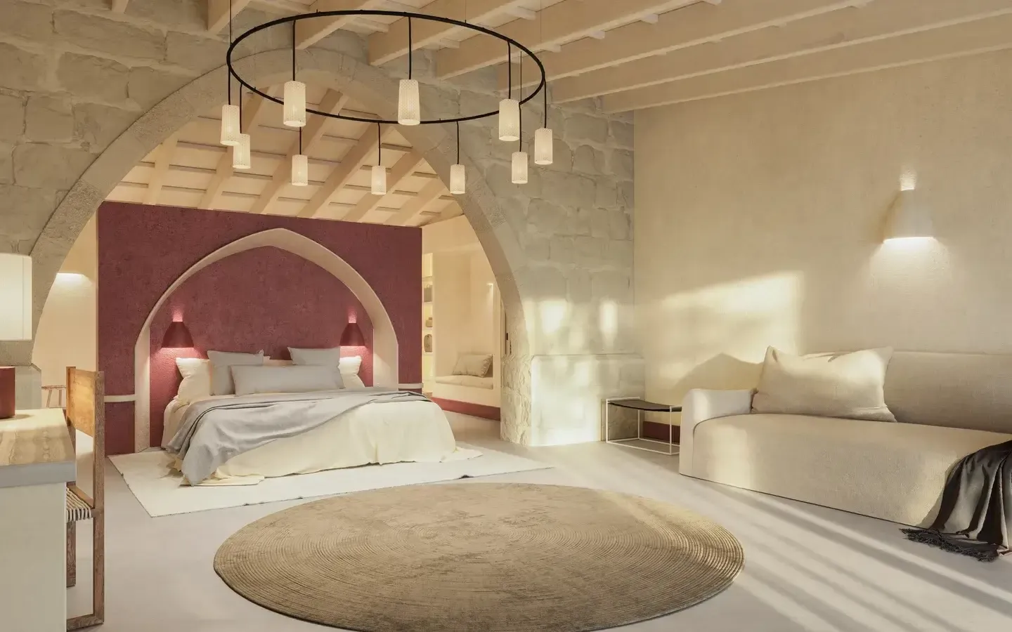 Amagatay, Balearic Islands — Arched bedroom with burgundy headwall, pendant lighting, stone architecture, neutral furnishings, and circular jute rug.