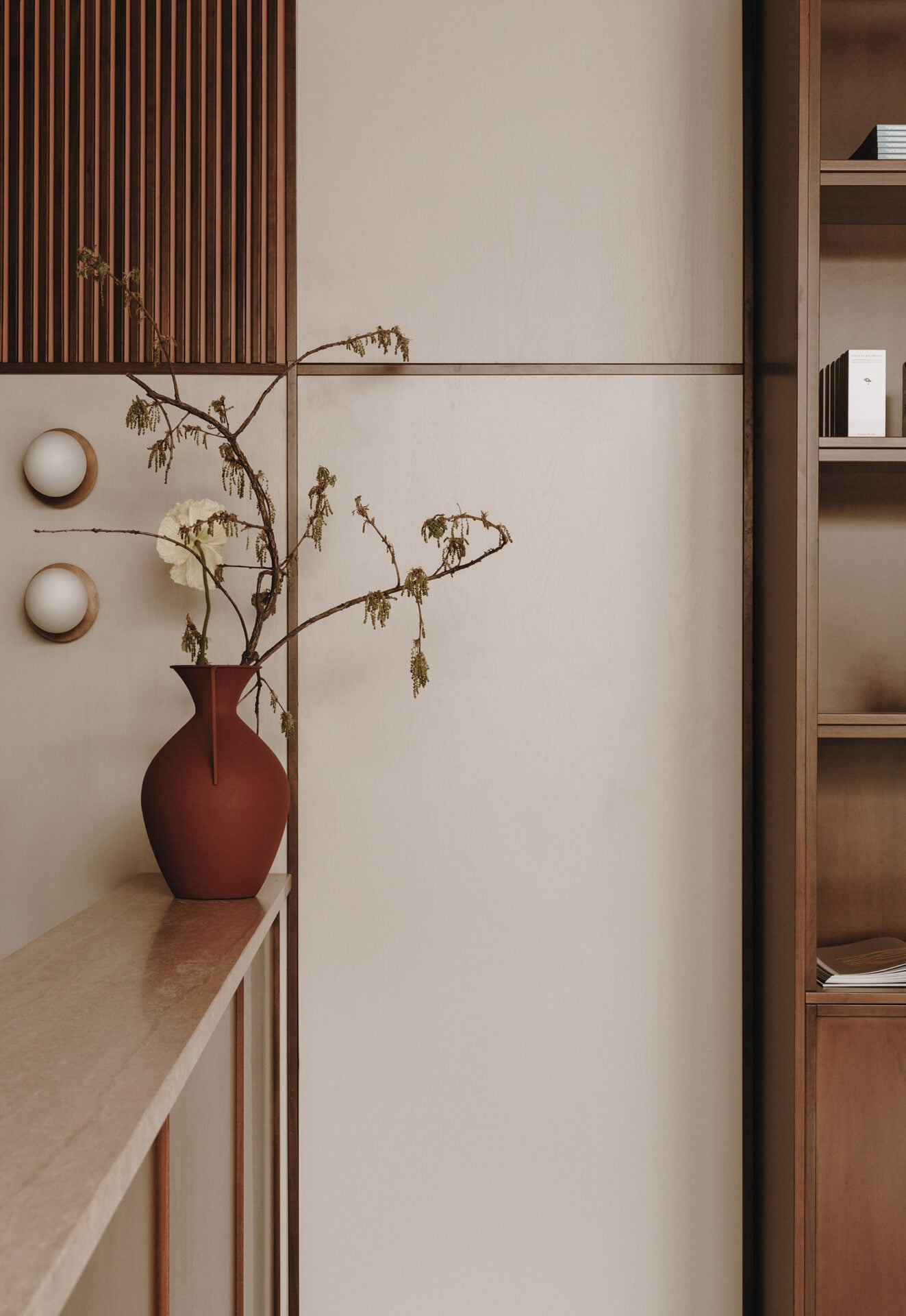 Parkhotel Mondschein, Europe — Minimalist corridor with dried botanicals in burgundy vessel, wooden shelving, and warm neutral palette evoking serene alpine hospitality design.