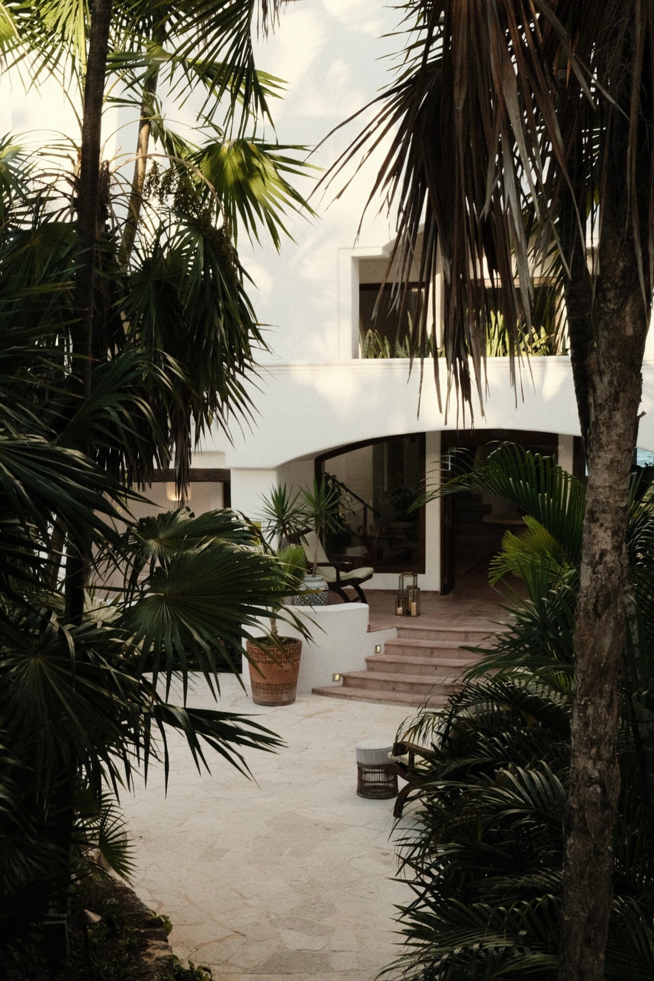 Maroma, A Belmond Hotel, Mexico — Modernist white architecture framed by palm trees, terrazzo courtyard with curved forms and natural light, tropical minimalist design.
