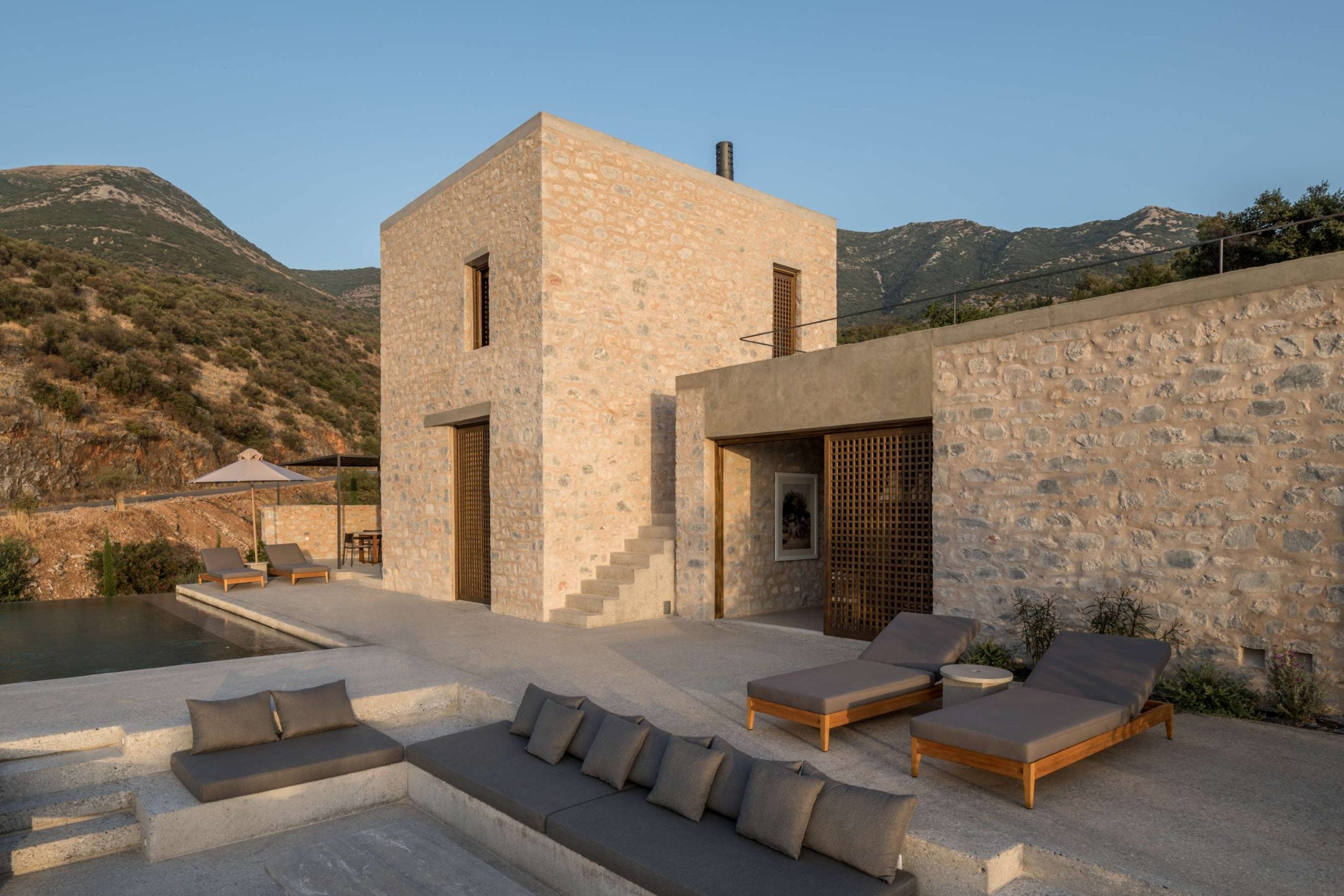 Seating area with lounge chairs and sunken in sofa of Monolithoi Villa 2 in Mone, Greece
