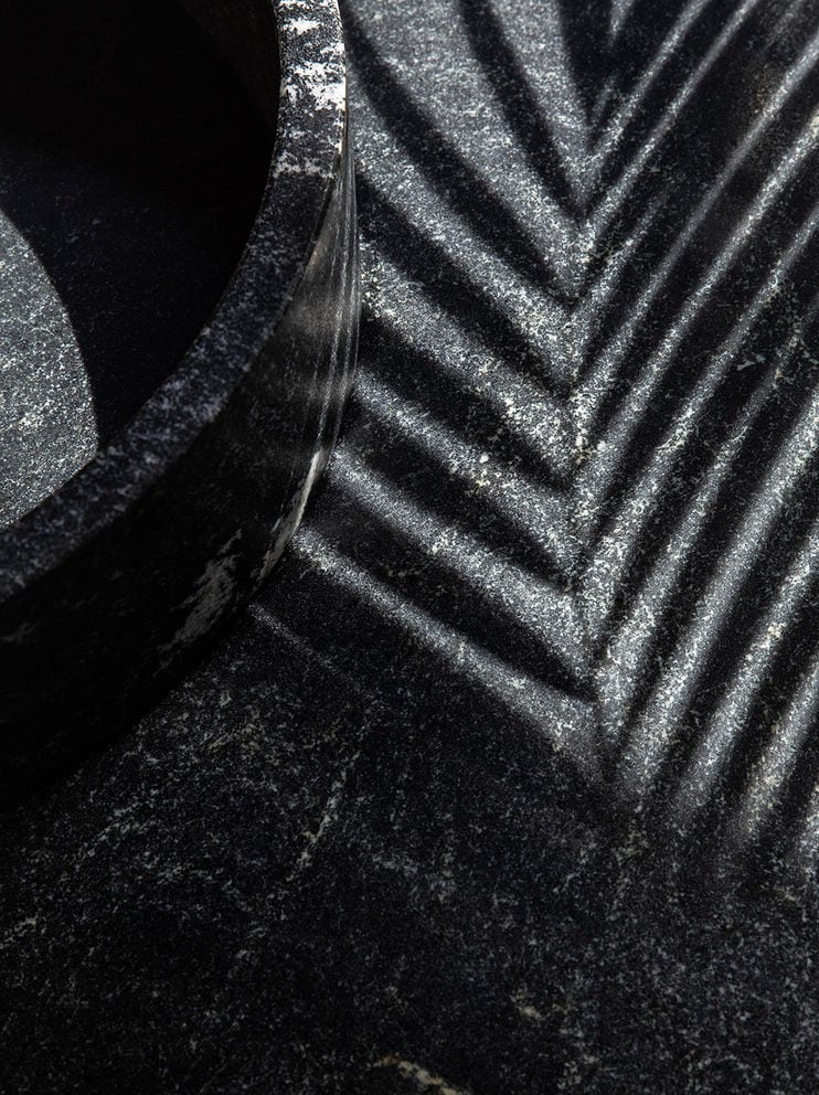 One&Only Mandarina, Mexico — Textured stone chevron pattern with dramatic side lighting casting geometric shadows, architectural detail emphasizing luxury material craftsmanship and modern design aesthetic.