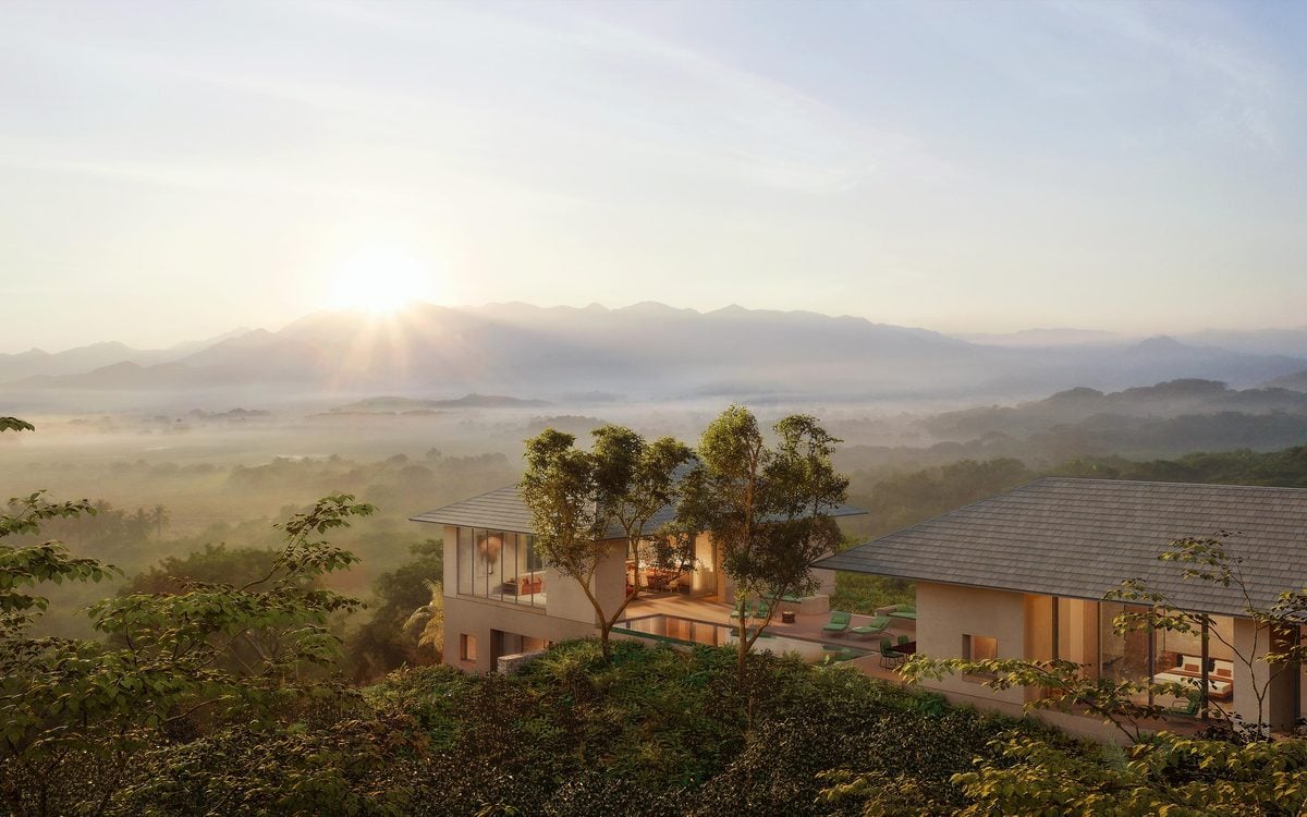One&Only Mandarina, Mexico — Modernist cliffside villa with warm stone facades and floor-to-ceiling windows overlooking misty valley at sunrise, surrounded by native vegetation.