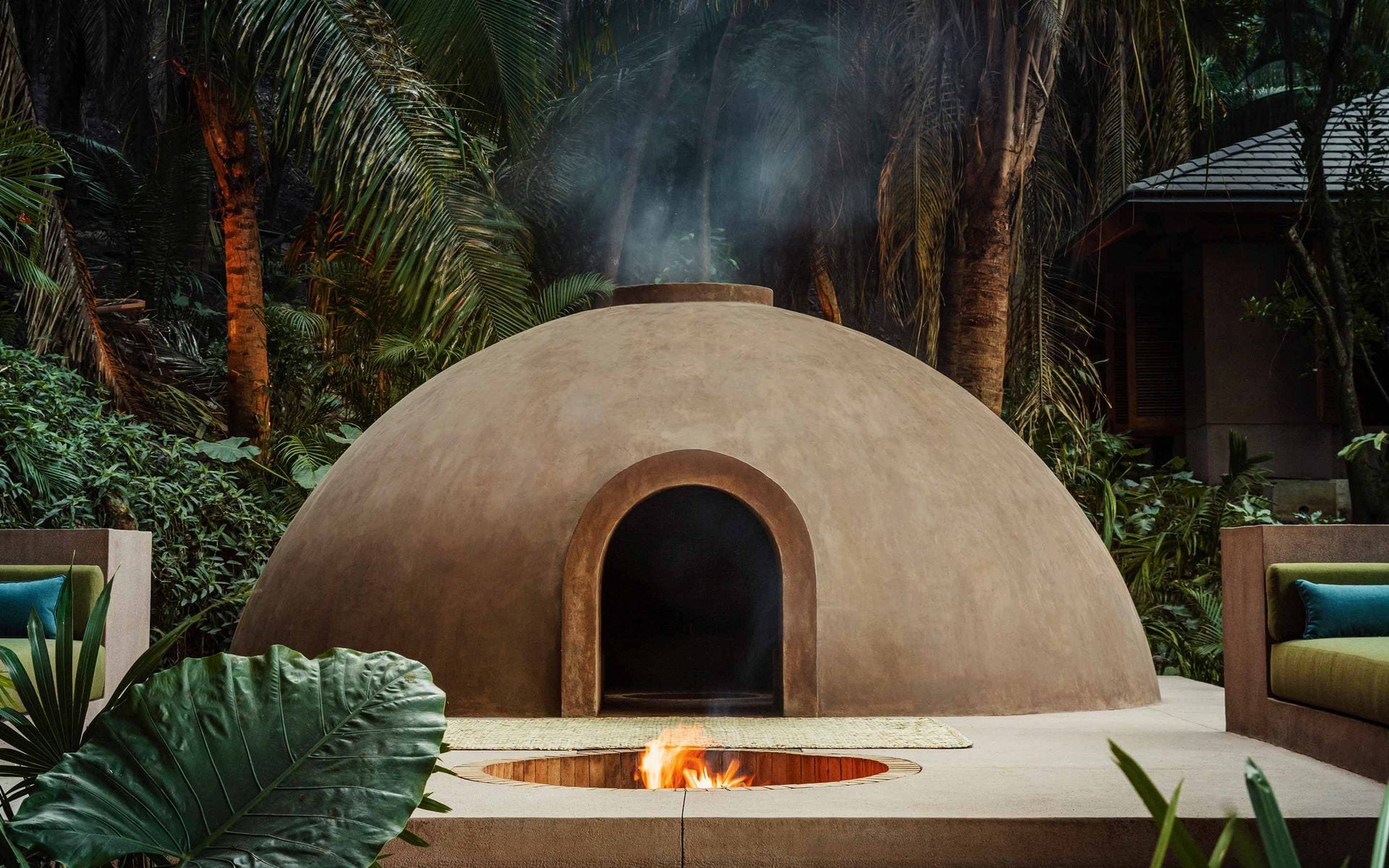 One&Only Spa, Mexico — Dome-shaped clay structure with arched entrance and sunken fire pit, surrounded by tropical palms and lush vegetation.