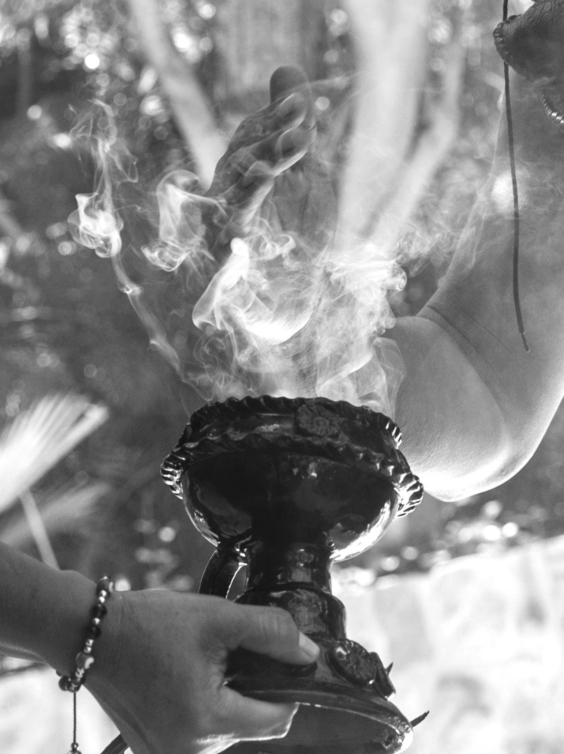 One&Only Mandarina, Mexico — Hands holding ceremonial vessel with smoking copal, atmospheric black and white detail of ritualistic hospitality moment.