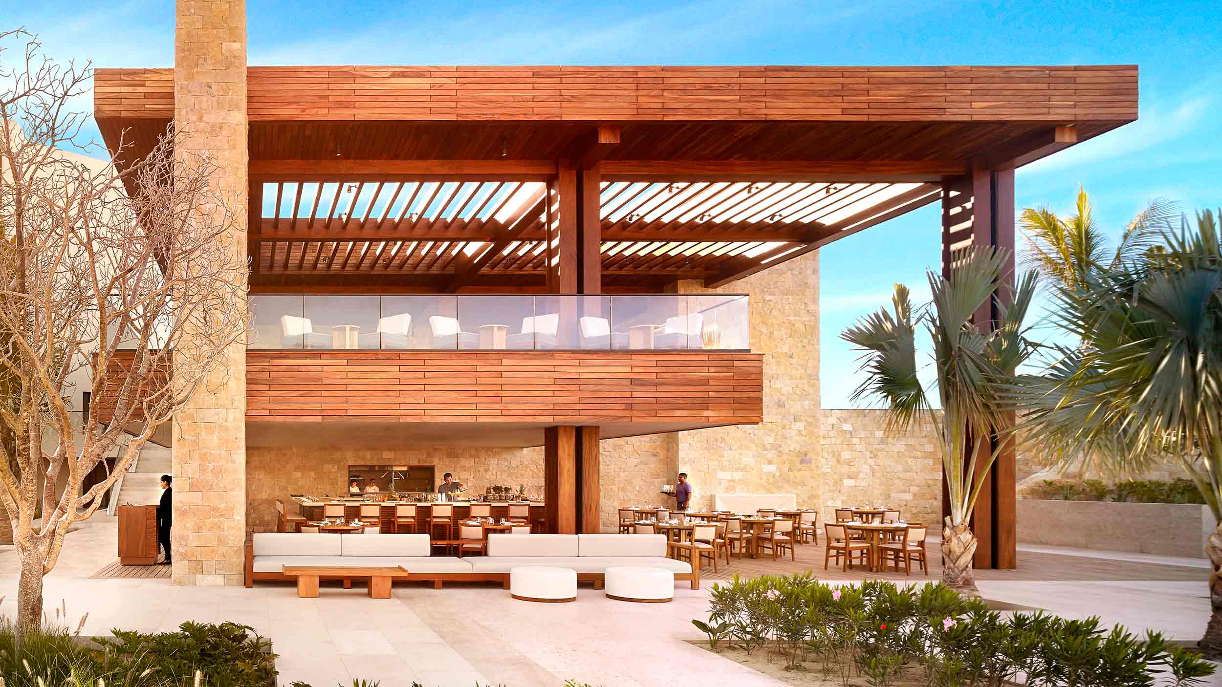 Pacific Restaurant, Mexico — Modernist dining pavilion with timber pergola, stone facade, and glass clerestory overlooking coastal landscape with palm trees.