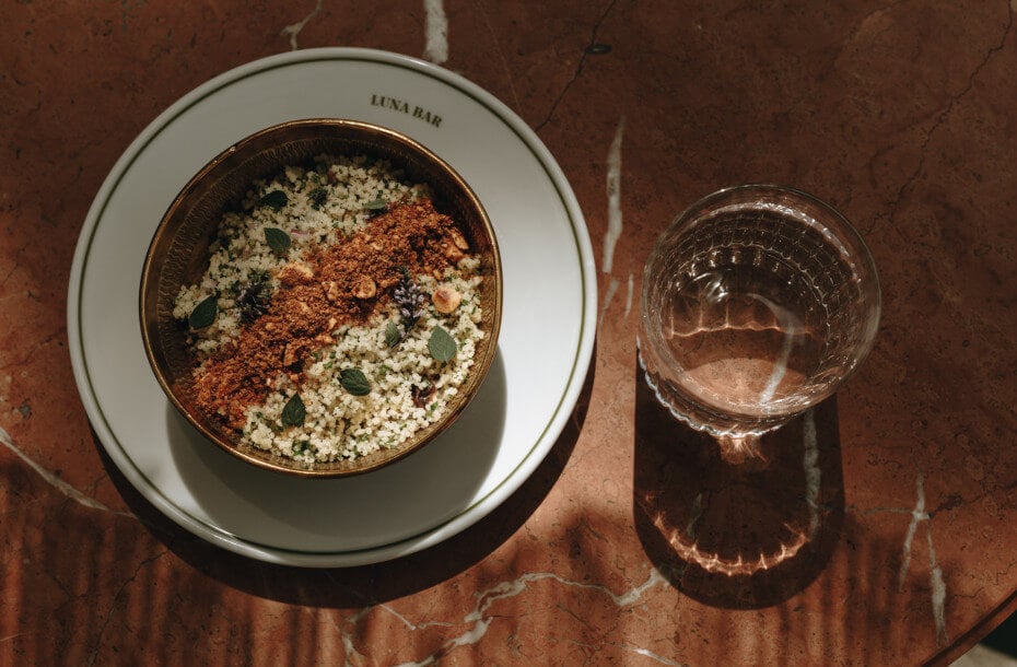 Parkhotel Mondschein, Europe — Minimalist plated dish with quinoa, spiced powder, and microgreens at Luna Bar, styled with natural light and marble surface.