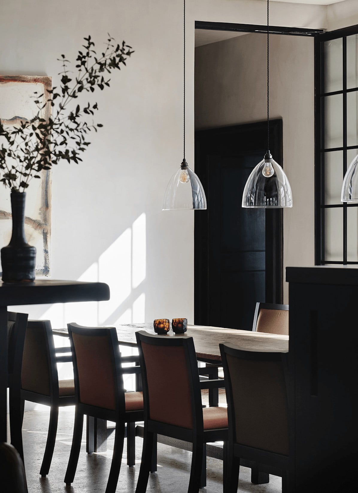 Purs, Europe — Modern dining room with black leather chairs, pendant lights, natural daylight, and minimalist aesthetic in luxury hospitality interior design.