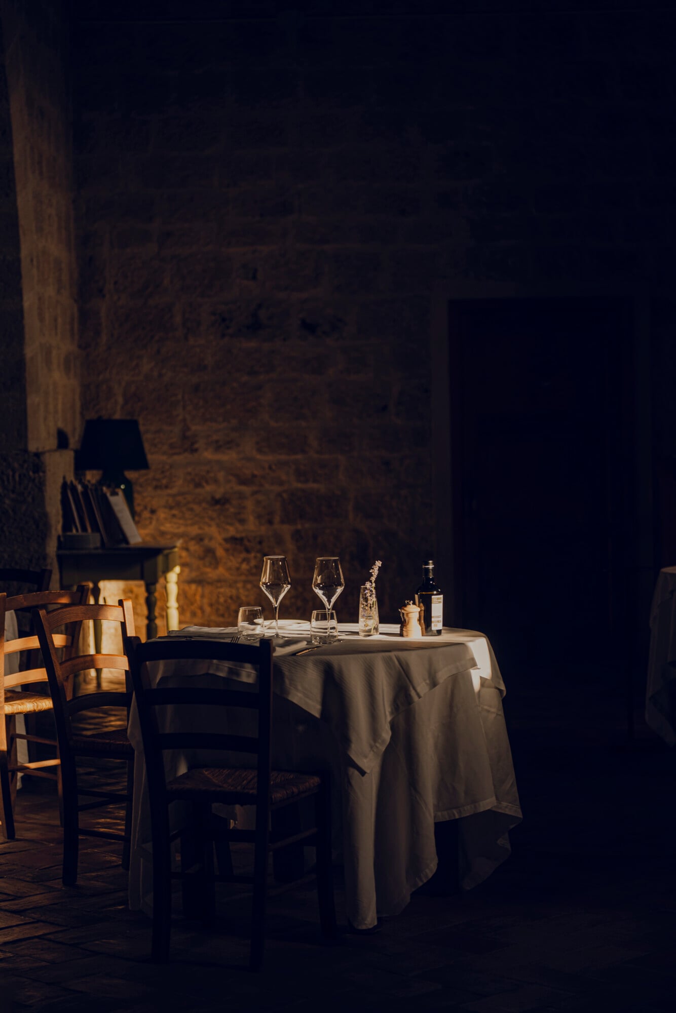 Romantic Dinner — Intimate candlelit dining table with wine glasses and stone walls, romantic Italian restaurant setting with warm ambient lighting.