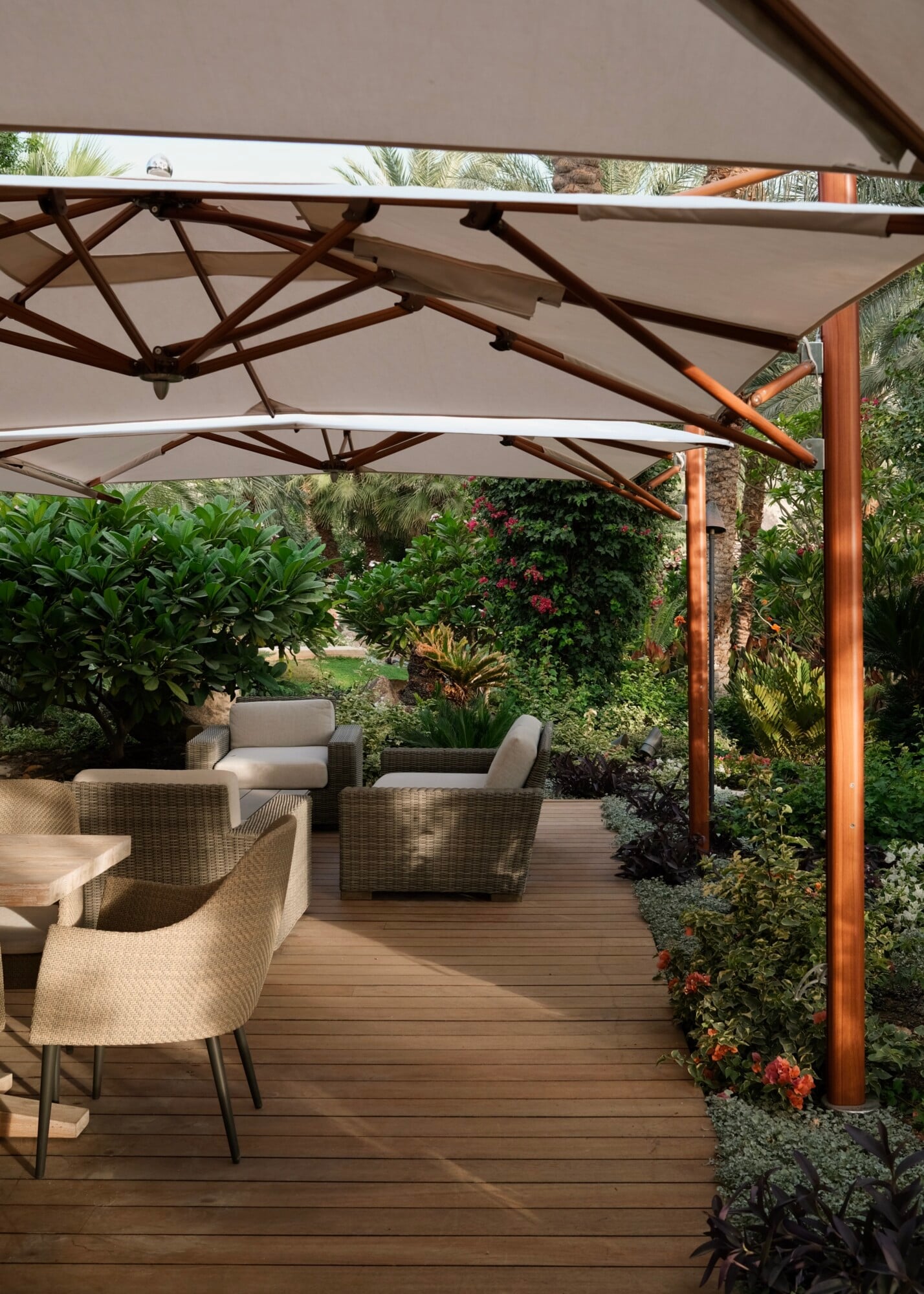 Sensei Porcupine Creek, North America — Shaded wooden deck with modern lounge furniture, latticed pergola, and lush tropical gardens creating serene outdoor sanctuary.