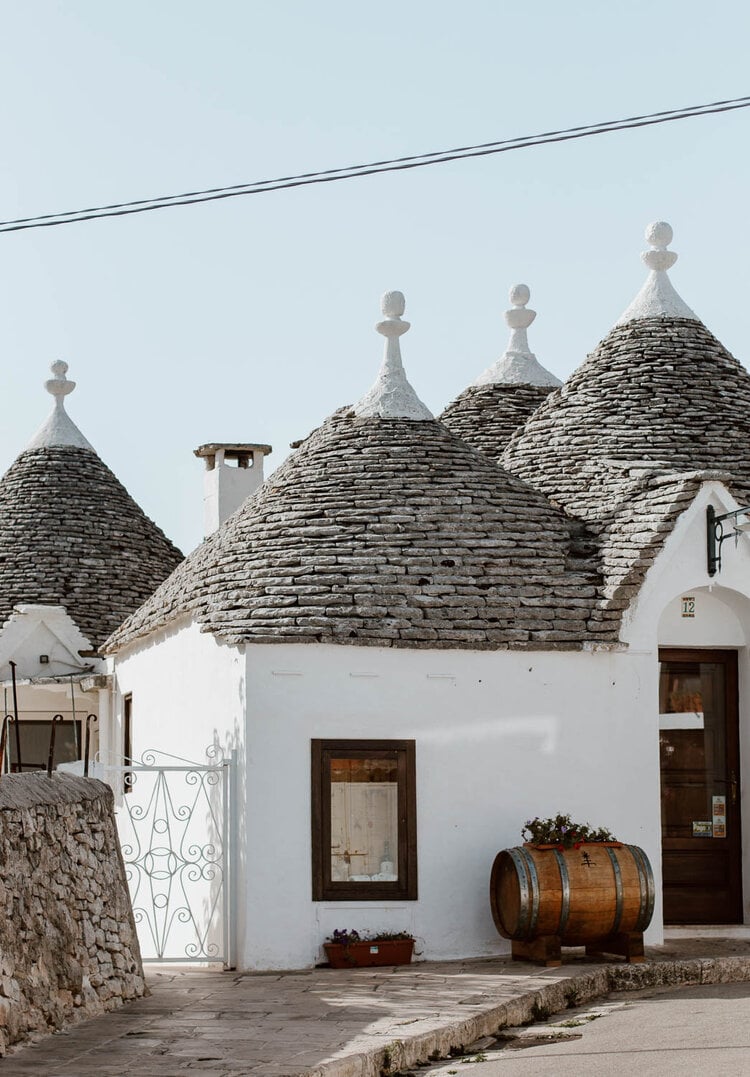 Trulli stone houses with conical roofs and white-washed walls in Alberobello, Italy — traditional Apulian architecture and rustic design details.