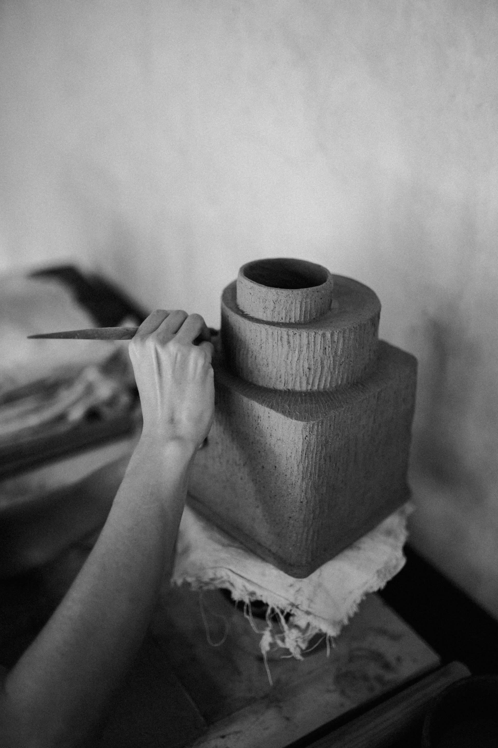 Tulum Treehouse, Mexico — Hands holding wooden vessel with textile wrap, carved wood grain detail, intimate craft artisanal aesthetic.